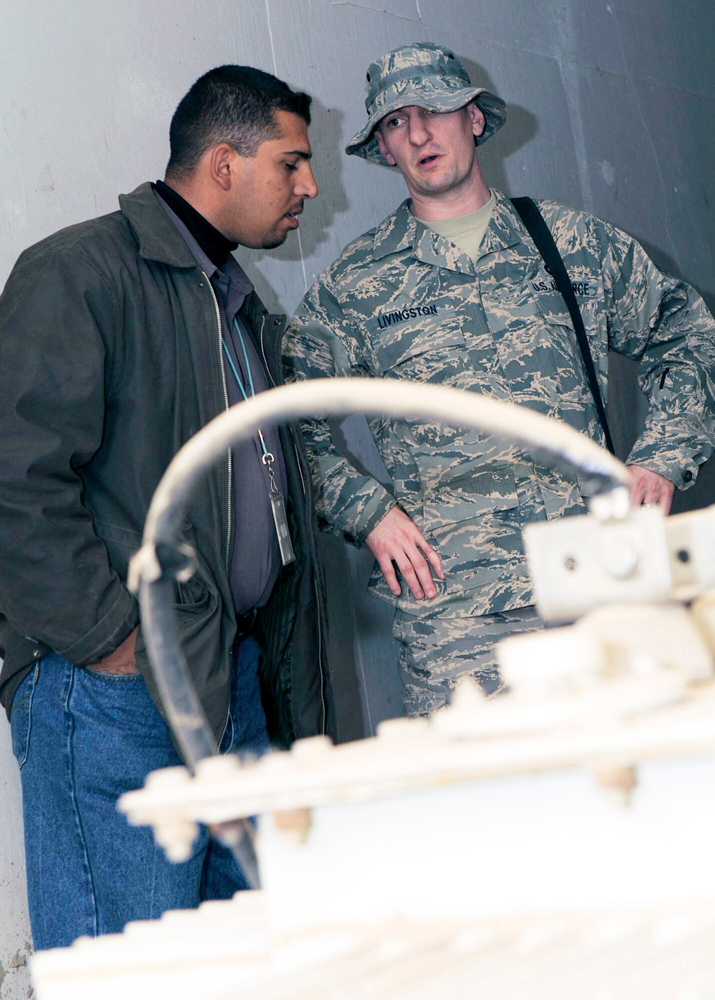 Staff Sgt. Todd Livingston, an electrician with the Joint Area Support Group in Baghdad talks to an Iraqi contractor Feb. 14 about procedures for the switch from generators to commercial power for Forward Operating Base Union III in Baghdad. The switchover took place Feb. 20. Sergeant Livingston is deployed from Ellsworth Air Force Base, S.D. and a native of Rochester, Minn. (U.S. Air Force photo/Senior Airman Jacqueline Romero) 
