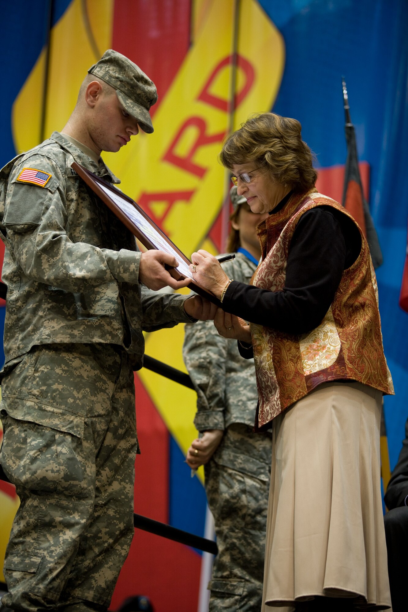 Evonne Koeppen, mother of a deploying 32nd Brigade Soldier, representing Wisconsin's military families, signs the Wisconsin's Military-Community Covenant during a large ceremony at the Dane County Veterans Memorial Coliseum in Madison, Feb. 17, 2009. The covenant, which will support many of the Airmen assigned to the 115th Fighter Wing, is an agreement between federal and state legislature, military and civic leaders to consolidate resources to provide the best possible care and support for Wisconsin service members and their families. (Wisconsin Department of Military Affairs photo by Army Staff Sgt. Joe Streeter)