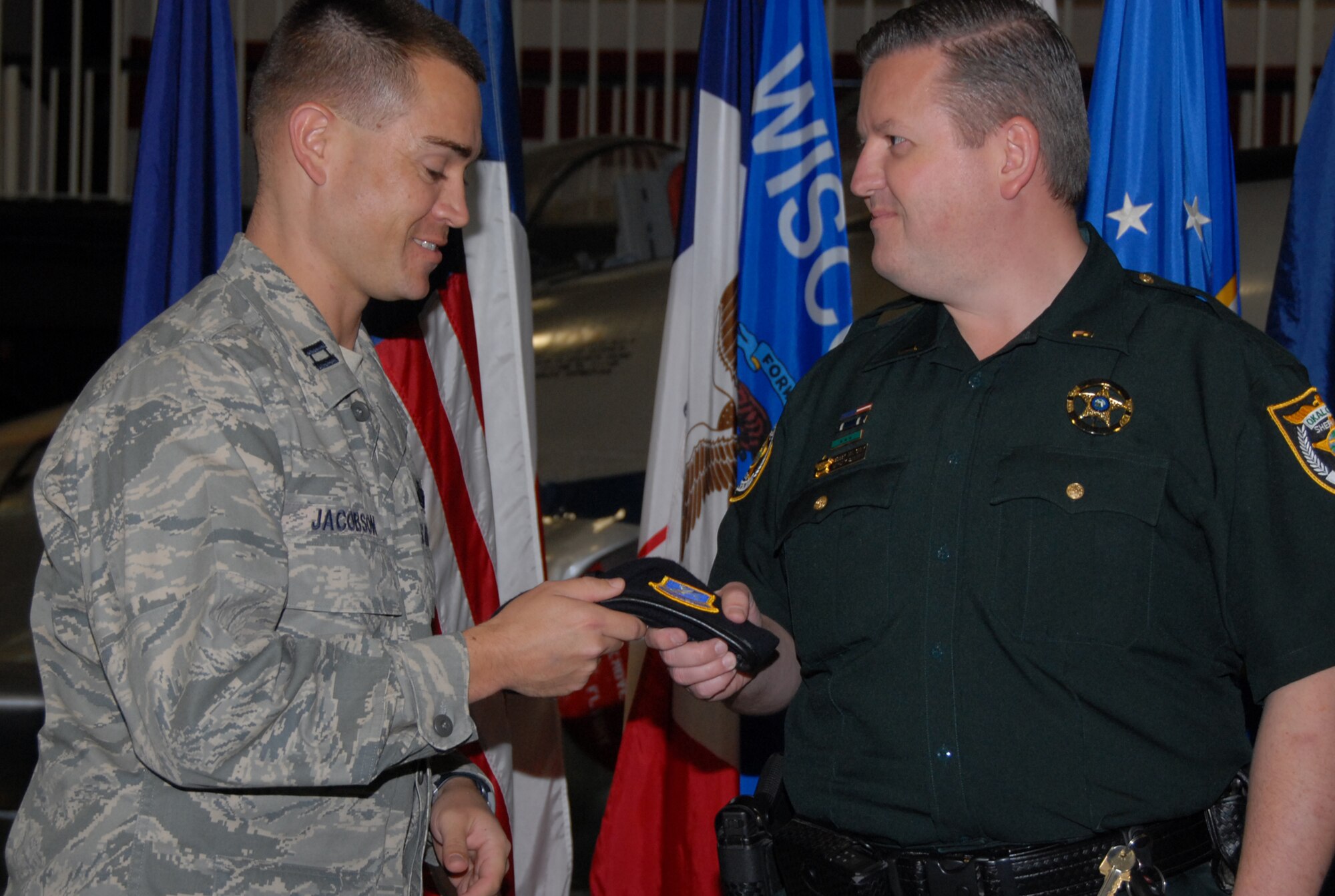 Capt. Benjamin Jacobson, 96th Ground Combat Training Squadron hands his new honorary commander Robert Maloney, an Air Force security forces beret making him an official member of the squadron during the 96th Air Base Wing Honorary Change of Command Ceremony Feb. 18 at the Air Armament Museum.  The honorary commanders program gives members of the local community a unique opportunity to interact with and learn about Eglin’s Airmen, their mission and the role they play in supporting the Air Force. In turn, honoraries may invite commanders to community functions, building and maintaining positive relationships between the military and local communities.  Air Force photo/Samuel King Jr.  