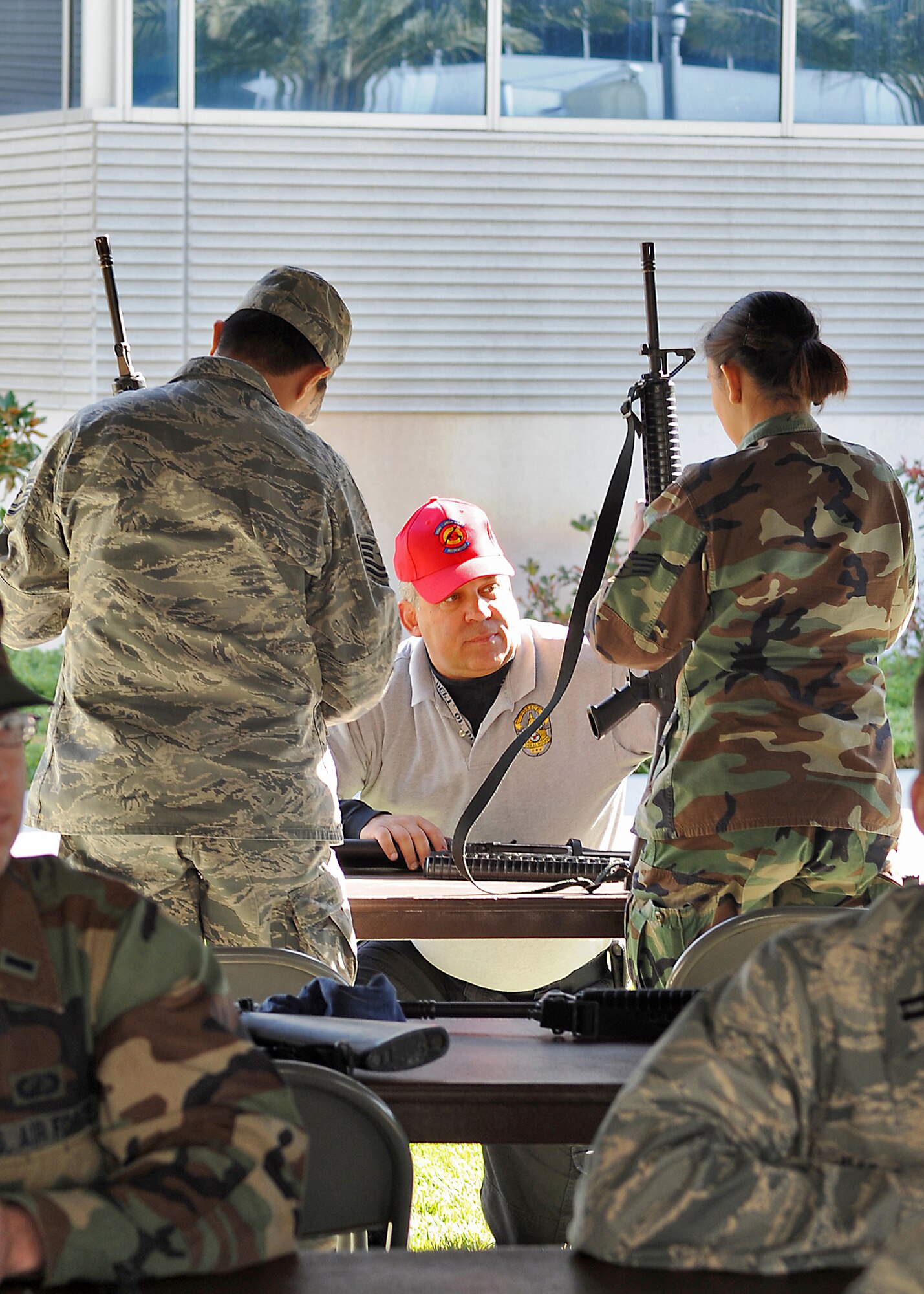 Officer Mark Tuttle (center) of the Security Forces Squadron helps troops reassemble an M16 during a bi-monthly ATSO (Ability To Survive and Operate) Rodeo, Feb. 12. Los Angeles Air Force Base conducted the exercise in preparation for an upcoming Operation Readiness Evaluation. Four stations were set up for weapons training, self aid and buddy care training, Post Attack Reconnaissance (PAR), and chemical/biological training, (Photo by Joe Juarez) (RELEASED)  