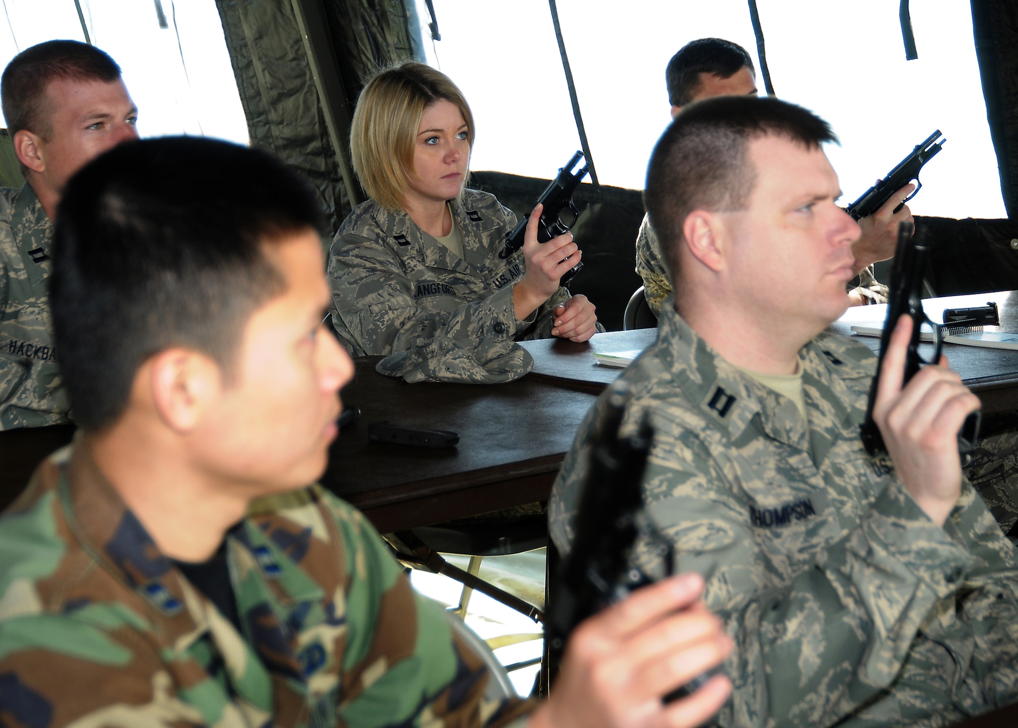 Capt. Dominique Langford (middle) learns the proper operation of a 9mm pistol during a bi-monthly ATSO (Ability To Survive and Operate) Rodeo, Feb. 12. Los Angeles Air Force Base conducted the exercise in preparation for an upcoming Operation Readiness Evaluation. Four stations were set up for weapons training, self aid and buddy care training, Post Attack Reconnaissance (PAR), and chemical/biological training, (Photo by Joe Juarez) (RELEASED)