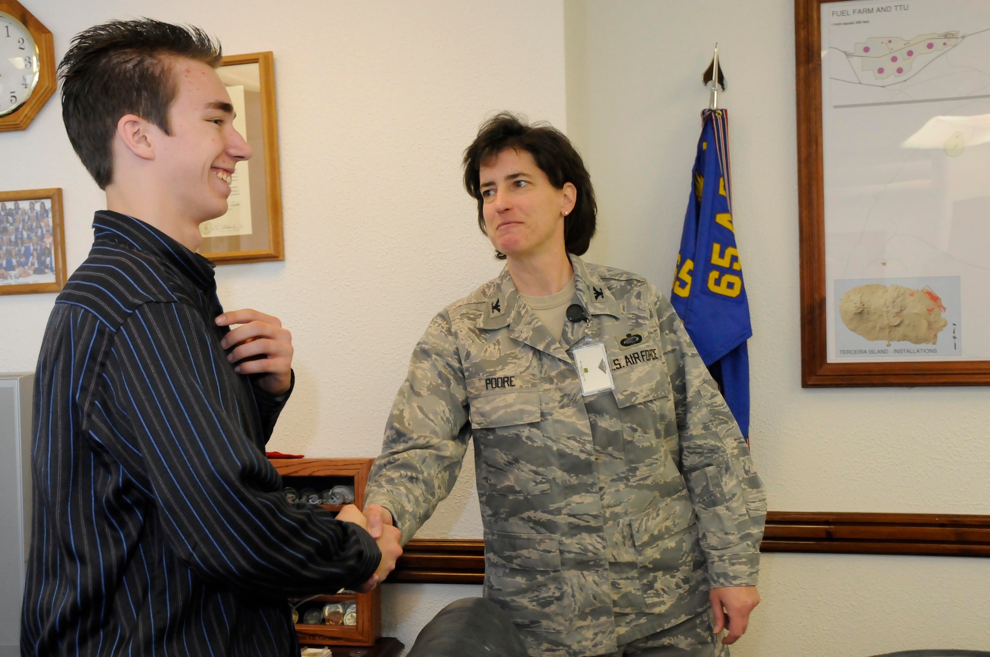 Col. Peggy Poore, 65th Air Base Wing commander, congratulates Michael, son of Chief Master Sgt. Kenneth Longacre of the 65th Mission Support Group, after his oath of enlistment into the Air Force’s Delayed Enlistment Program here Feb. 6. (Photo by Guido Melo)
