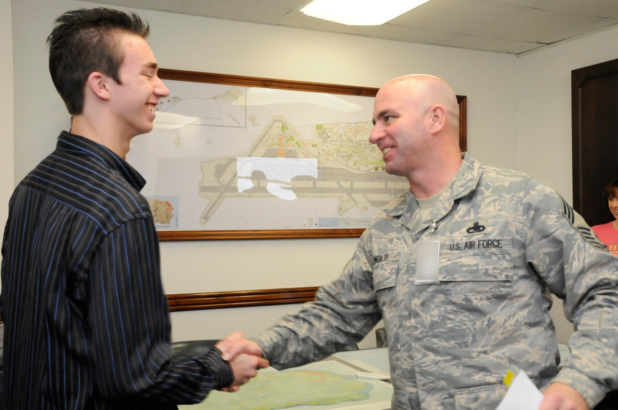 Chief Master Sgt. Kenneth Longacre, 65th Mission Support Group superintendent congratulates his son, Michael, after Michael’s oath of enlistment into the Air Force’s Delayed Enlistment Program here Feb. 6. Michael took the oath of enlistment after he decided he would like to join the Air Force and follow in his father’s footsteps.  (Photo illustration by Guido Melo)