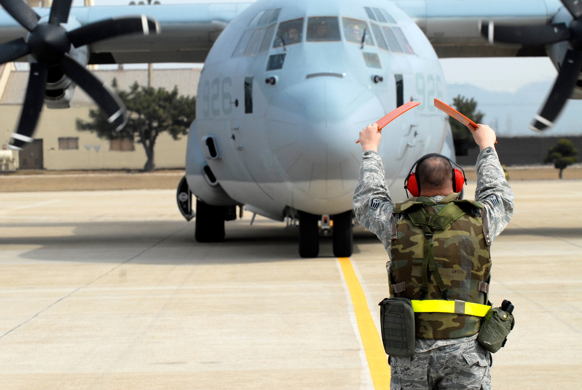 Staff Sgt. Daniel Jenkins, 8th Maintenance Squadron, guides a Marine Corps KC-130J Super Hercules from Marine Air Station Futenma, Okinawa, Japan, to its parking space at Kunsan Air Base, Republic of Korea, Feb 23, 2009. The Marines, here in support of the upcoming exercise Key Resolve, are giving the Airmen at Kunsan a chance to practice accepting follow-on forces during the 8th Fighter Wing's local Operational Readiness Exercise. (U.S. Air Force Photo by SSgt Jason Colbert)