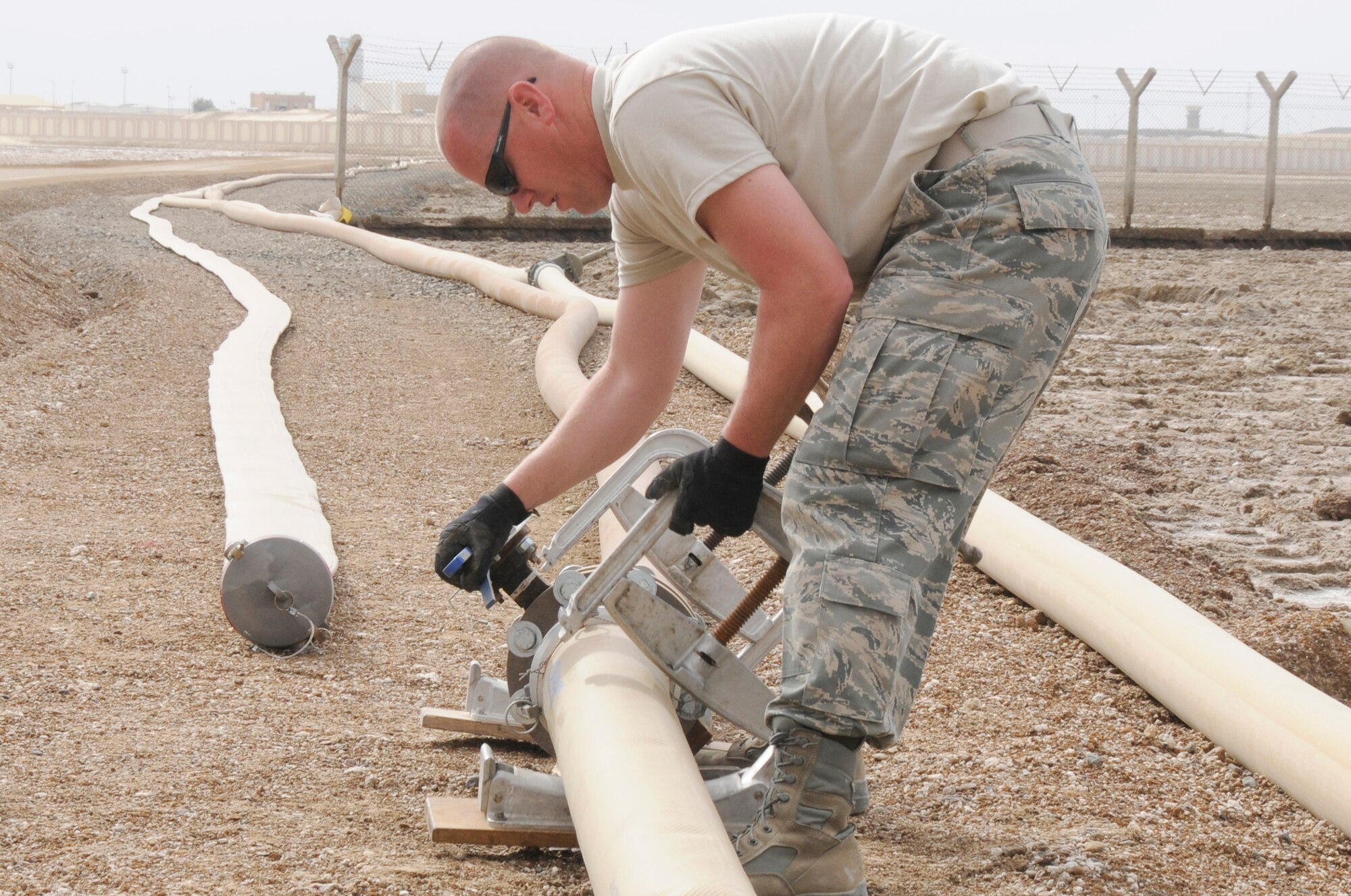 SOUTHWEST ASIA - Tech Sgt. David Butts, 380th Expeditionary Logistics Readiness Squadron, fuels flight, puts a hose clamp on a fuel line, Feb 7. The clamp allows the lines to be disconnected without completely draining the fuel to allow a faster transition to the new fuel lines. The fuels flight upgraded the fuel line named "python", changing out 5000ft, upgrading the old worn line ensuring a steady flow of fuel to the base. The fuels flight will replace an additional 3000ft within the next few weeks. Sergeant Butts is deployed from Nellis AFB and hails from Las Vegas, Nev. (U.S. Air Force photo by Senior Airman Brian J. Ellis) (Released)