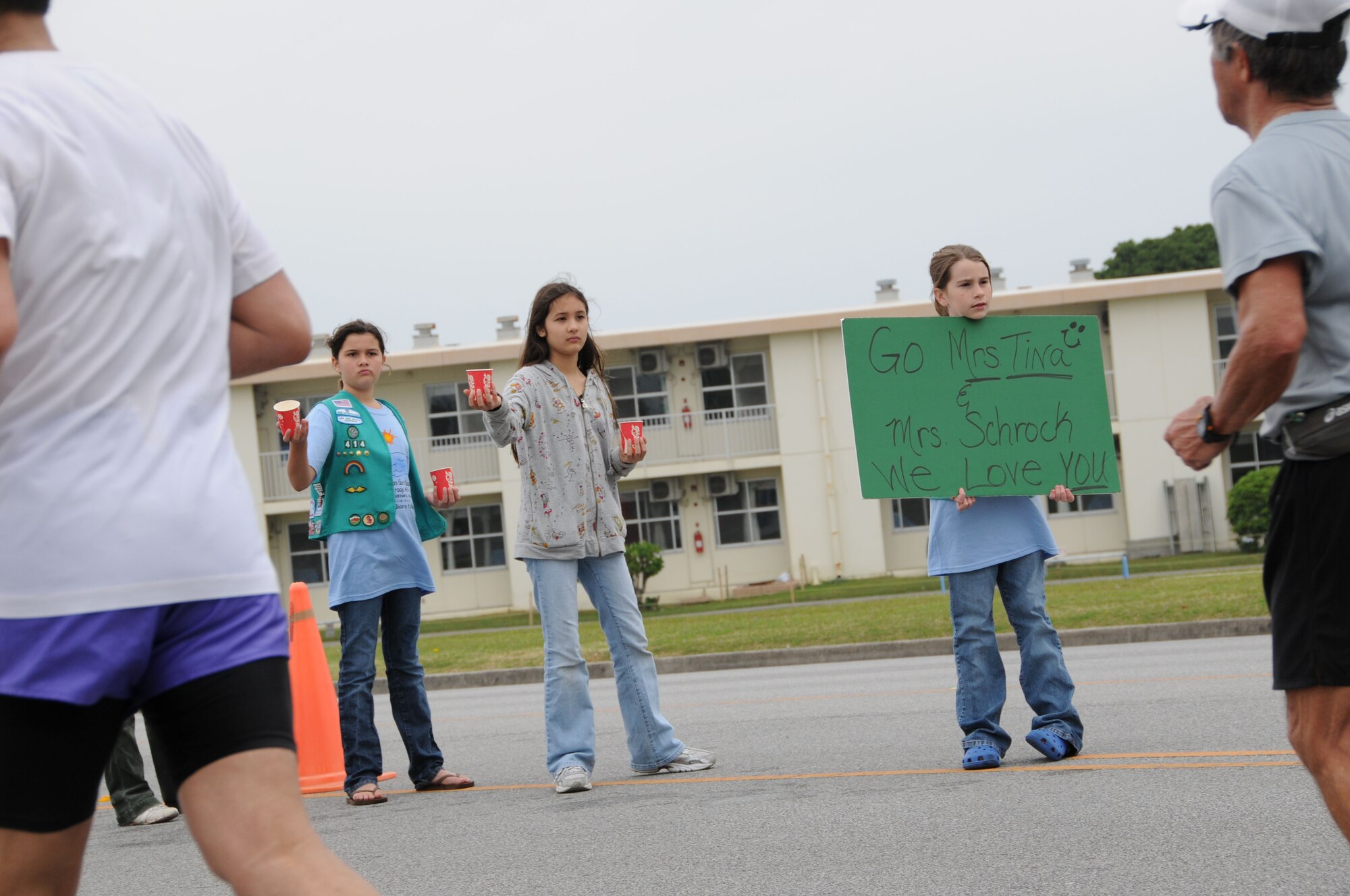 Girl scouts provide water and cheer on runners in the Okinawa marathon Feb. 22 at Kadena Air Base, Japan. Team Kadena volunteers encouraged and provided water to runners as they participated in the Kadena Air Base portion of the marathon. (U.S. Air Force Photo/Staff Sgt. Darnell T. Cannady)