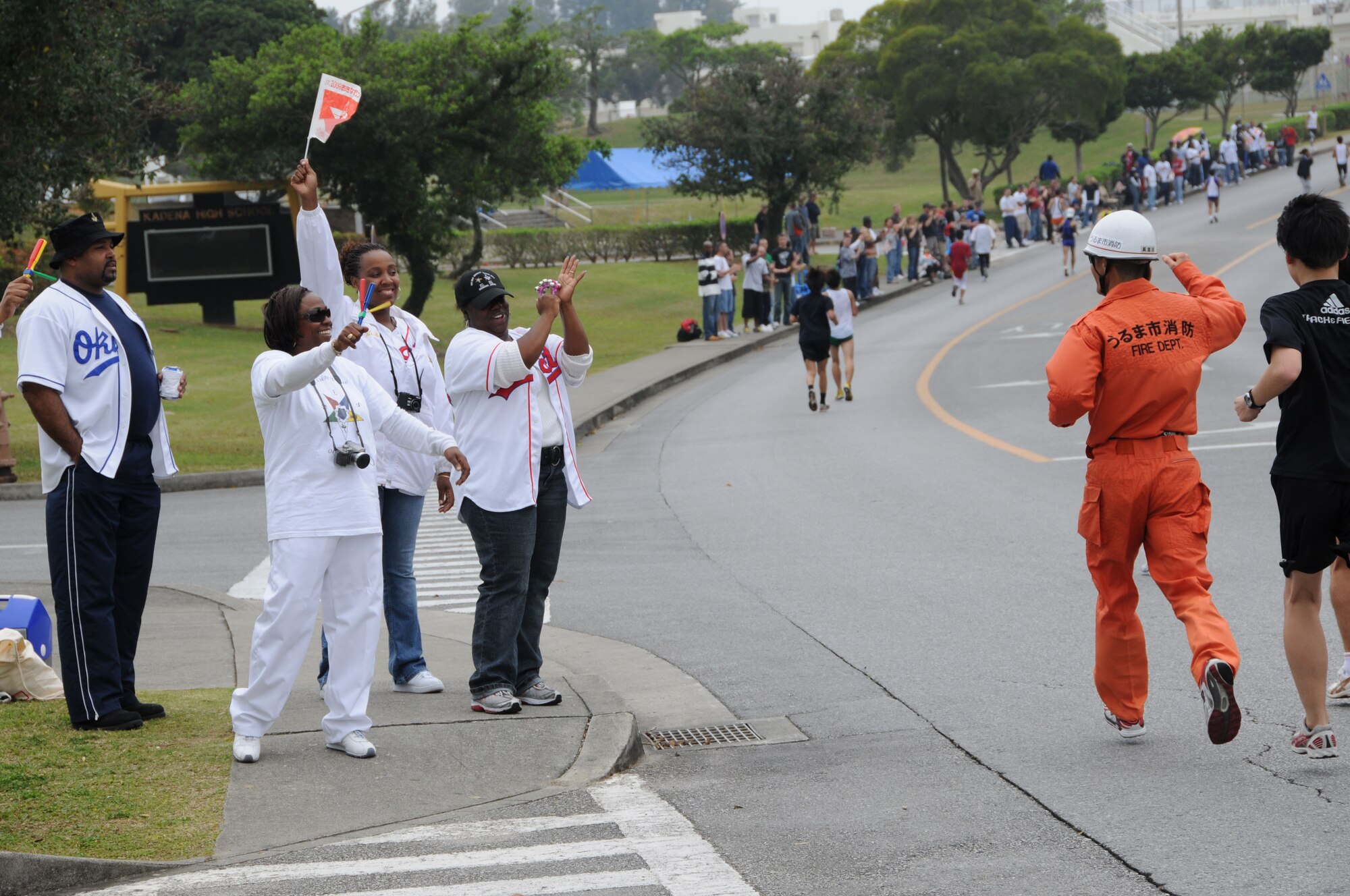 Volunteers cheer for runners in the Okinawa marathon Feb. 22 at Kadena Air Base, Japan. Team Kadena volunteers encouraged and provided water to runners as they participated in the Kadena Air Base portion of the marathon. (U.S. Air Force Photo/Staff Sgt. Darnell T. Cannady)