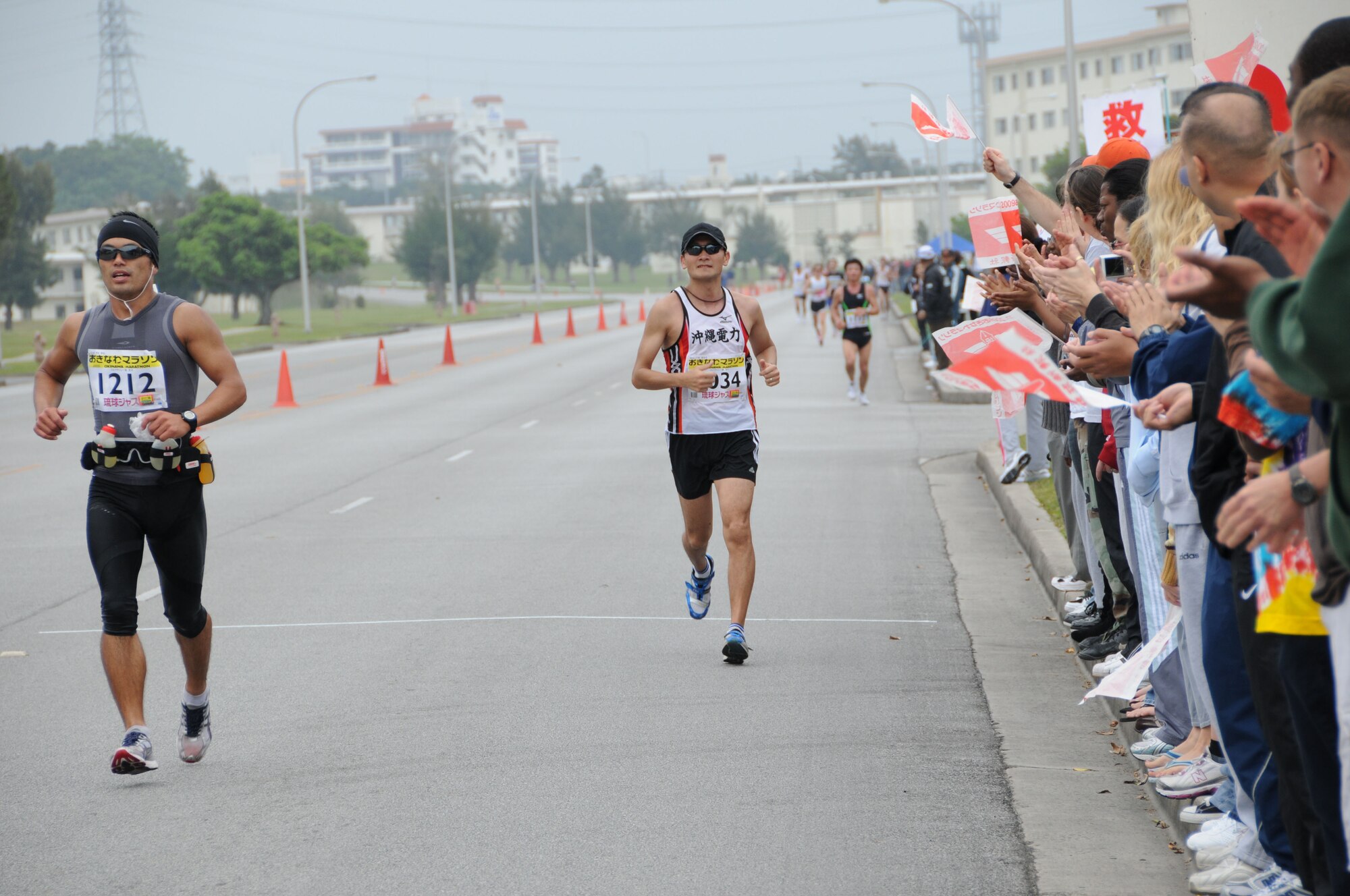 Volunteers cheer on runners in the Okinawa marathon Feb. 22 at Kadena Air Base, Japan. Team Kadena volunteers encouraged and provided water to runners as they participated in the Kadena Air Base portion of the marathon. (U.S. Air Force Photo/Staff Sgt. Darnell T. Cannady)