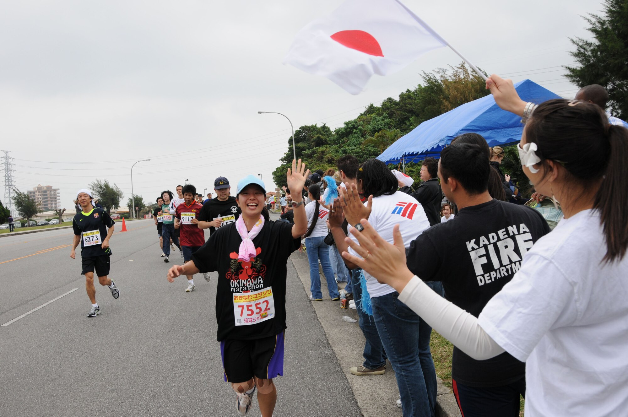 Volunteers cheer for runners in the Okinawa marathon Feb. 22 at Kadena Air Base, Japan. Team Kadena volunteers encouraged and provided water to runners as they participated in the Kadena Air Base portion of the marathon. (U.S. Air Force Photo/Staff Sgt. Darnell T. Cannady)