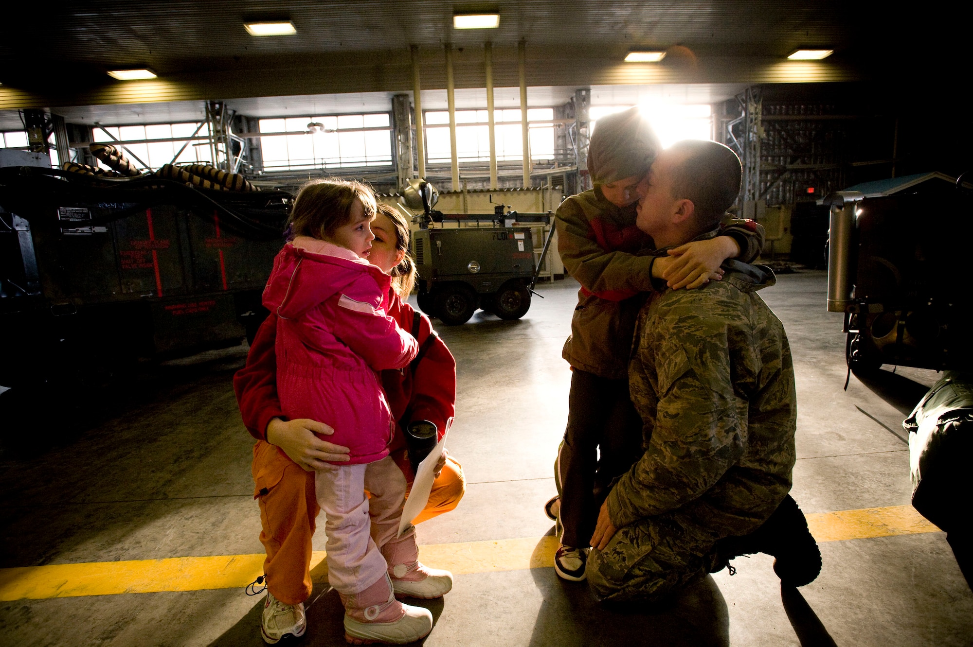 MISAWA AIR BASE, Japan -- Staff Sgt. Thomas Elmore, 13th Aircraft Maintenance Unit crewchief, says goodbye to his family in an aircraft hangar Feb. 24, 2009. Sergeant Elmore is deploying with his unit to South Korea in support of the 13th Fighter Squadron. Sergeant Elmore and his family are from Louisville, Ky. (U.S. Air Force photo by Staff Sgt. Samuel Morse)