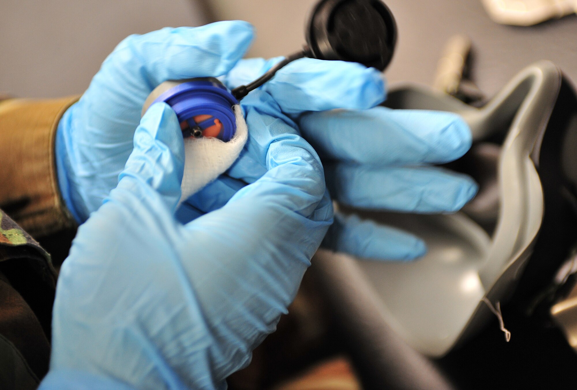 Airman 1st Class Jennifer Galligher, Aircrew Life Support Journeyman, 18th Aggressor Squadron, cleans an oxygen mask inhalation valve Feb. 23, 2008, Eielson Air Force Base, Alaska. The mask is made of several pieces that need to be thoroughly cleaned and inspected routinely. (U.S. Air Force photo/Airman 1st Class Willard E. Grande II)