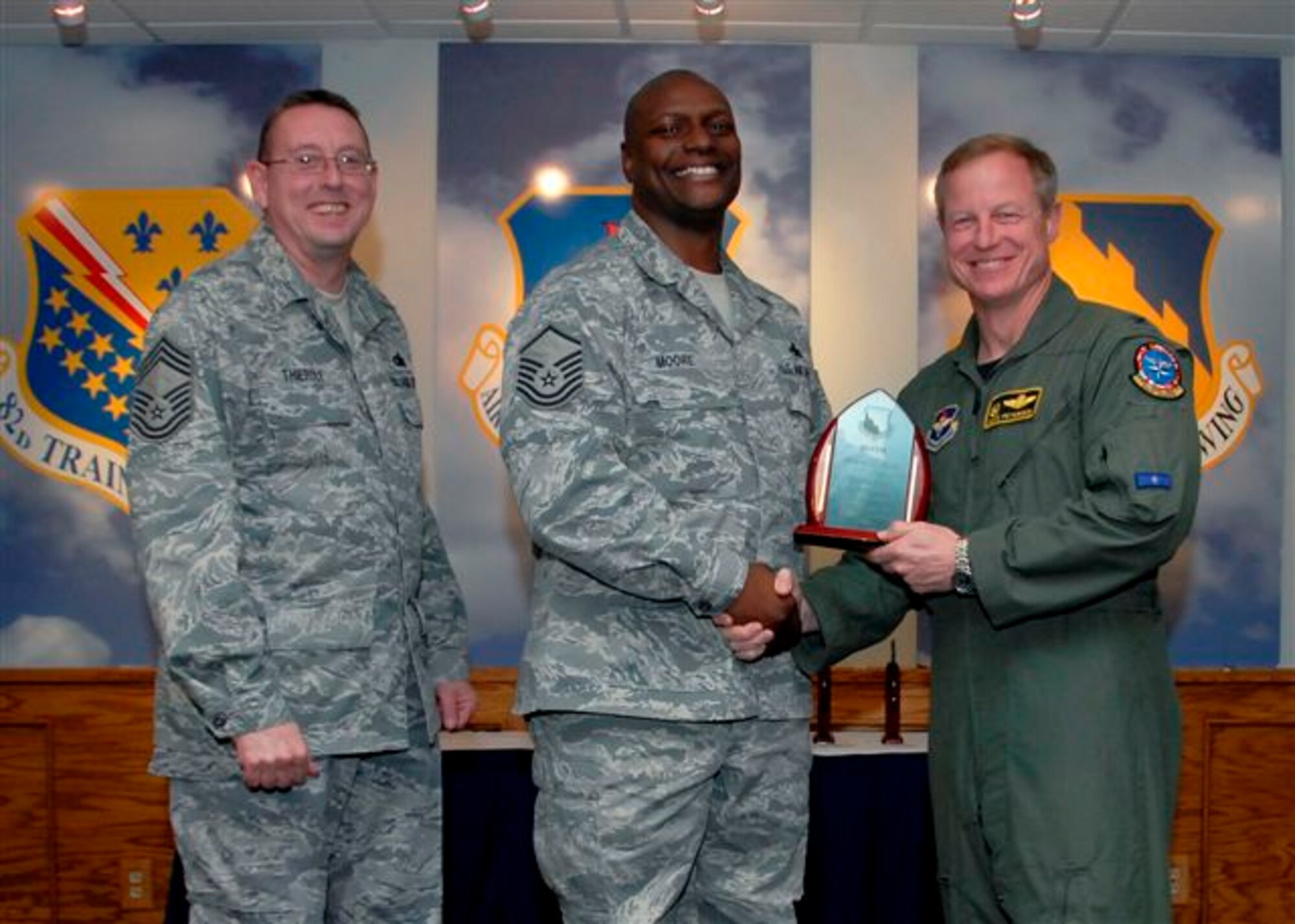 Master Sgt. Frankie Moore, 80th Flying Training Wing, accepts the Senior NCO of the Quarter award from 80th FTW Commander  Col. David Petersen and 80th FTW Superintendant Chief Master Sgt. Norman Thierolf at the wing's quarterly award luncheon. (U.S. Air Force photo)