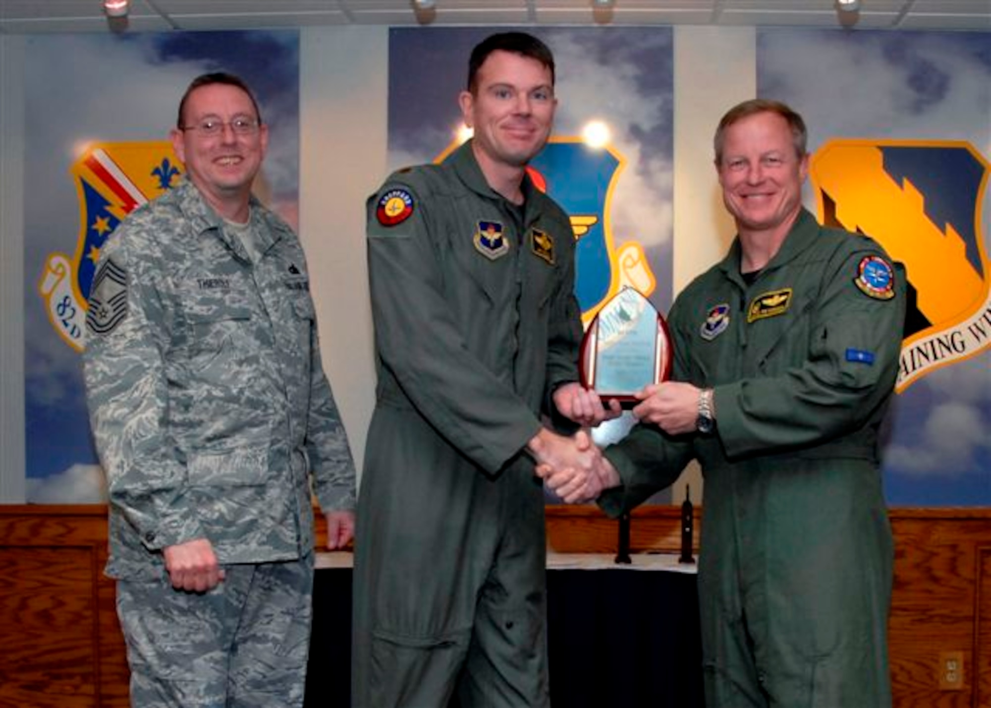 Maj. James McGlone, 80th Operations Group, accepts the Field Grade Officer of the Quarter Award, for the first quarter from Col. David Petersen, commander of the 80th Flying Training Wing at the wing's quarterly award luncheon. Also pictured is 80th FTW Superintendant Chief Master Sgt. Norman Thierolf. (U.S. Air Force photo)