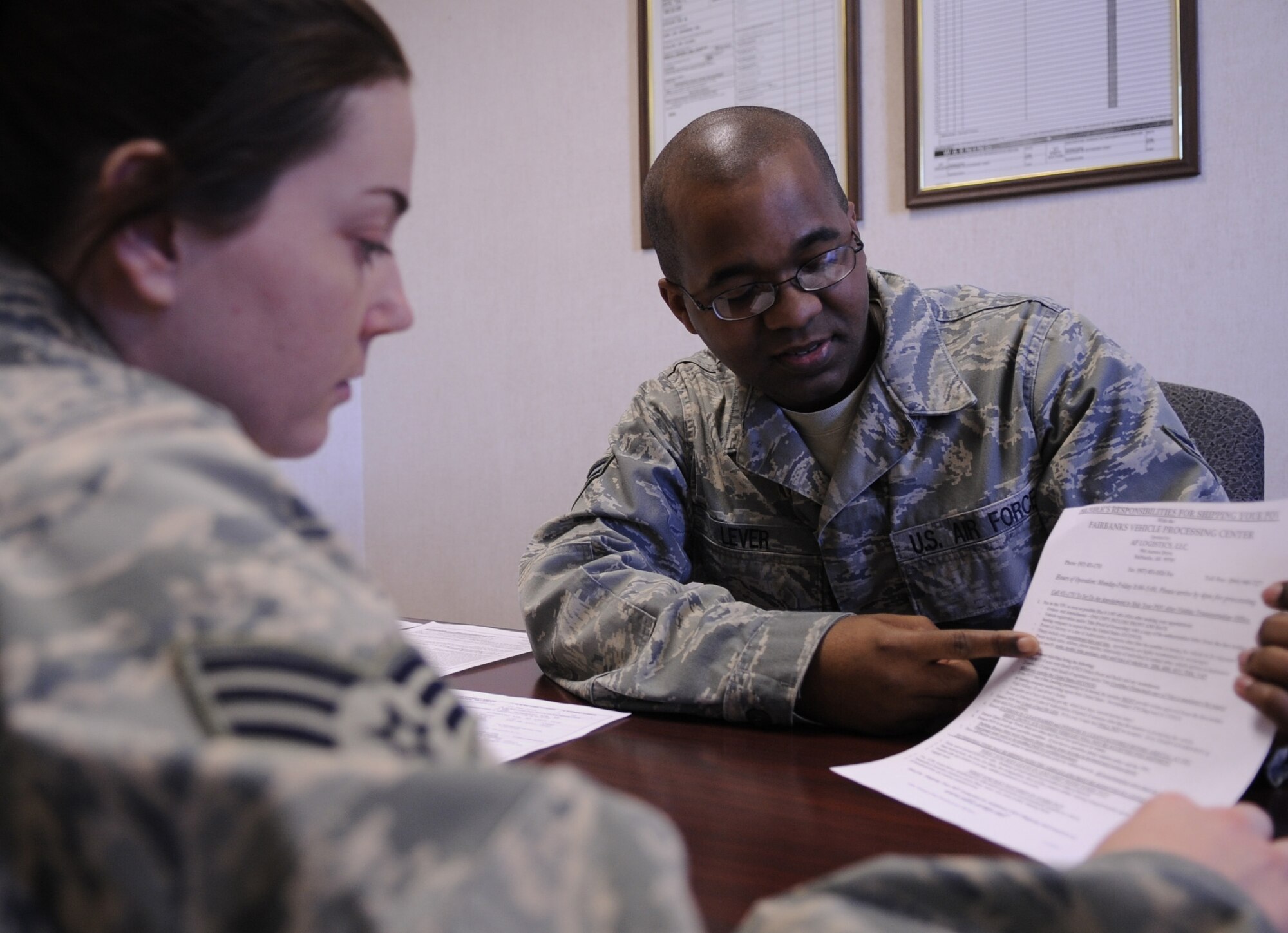 Airman 1st Class Joshua Lever briefs Senior Airman Michelle Farris, both 354th Logistics Readiness Squadron Traffic Management Specialist at TMO Feb. 23, 2009 at Eielson Air Force Base, Alaska.  TMO briefs all active duty members with orders to relocate, informing them of their entitlements as well as what they are allocated to move.  (U.S. Air Force photo/Airman 1st Class Laura Max)