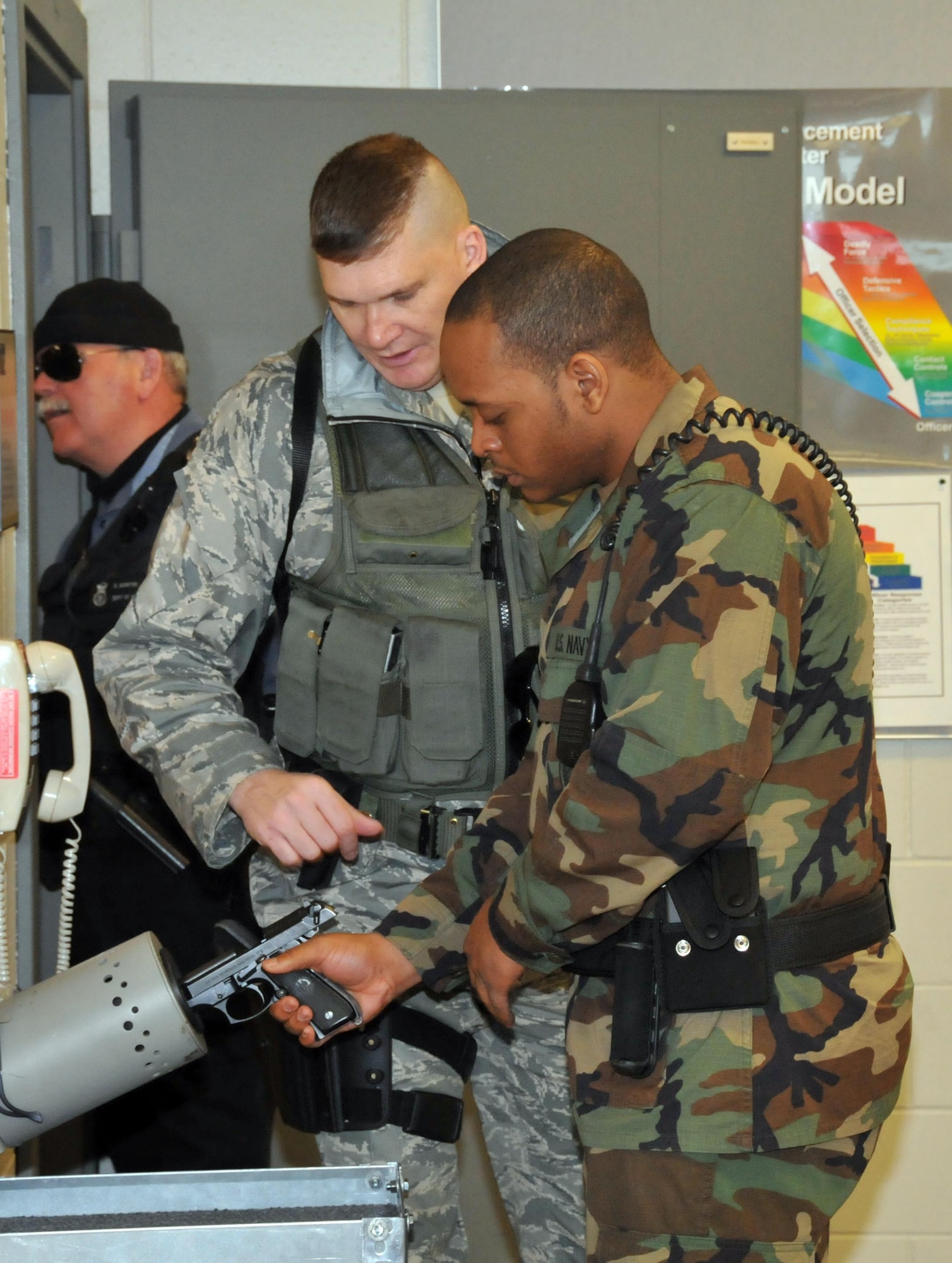 Staff Sgt. Robert McDonald, 934th Security Forces Squadron, (left) verifies proper weapons clearing procedures by Navy Master at Arms Seaman Rafael Banks before guard mount. Navy members train and work with 934th Airlift Wing Security Forces Squadron members to provide security at Minneapolis St. Paul International Airport Air Reserve Station. (Air Force Photo/Master Sgt. Paul Zadach)