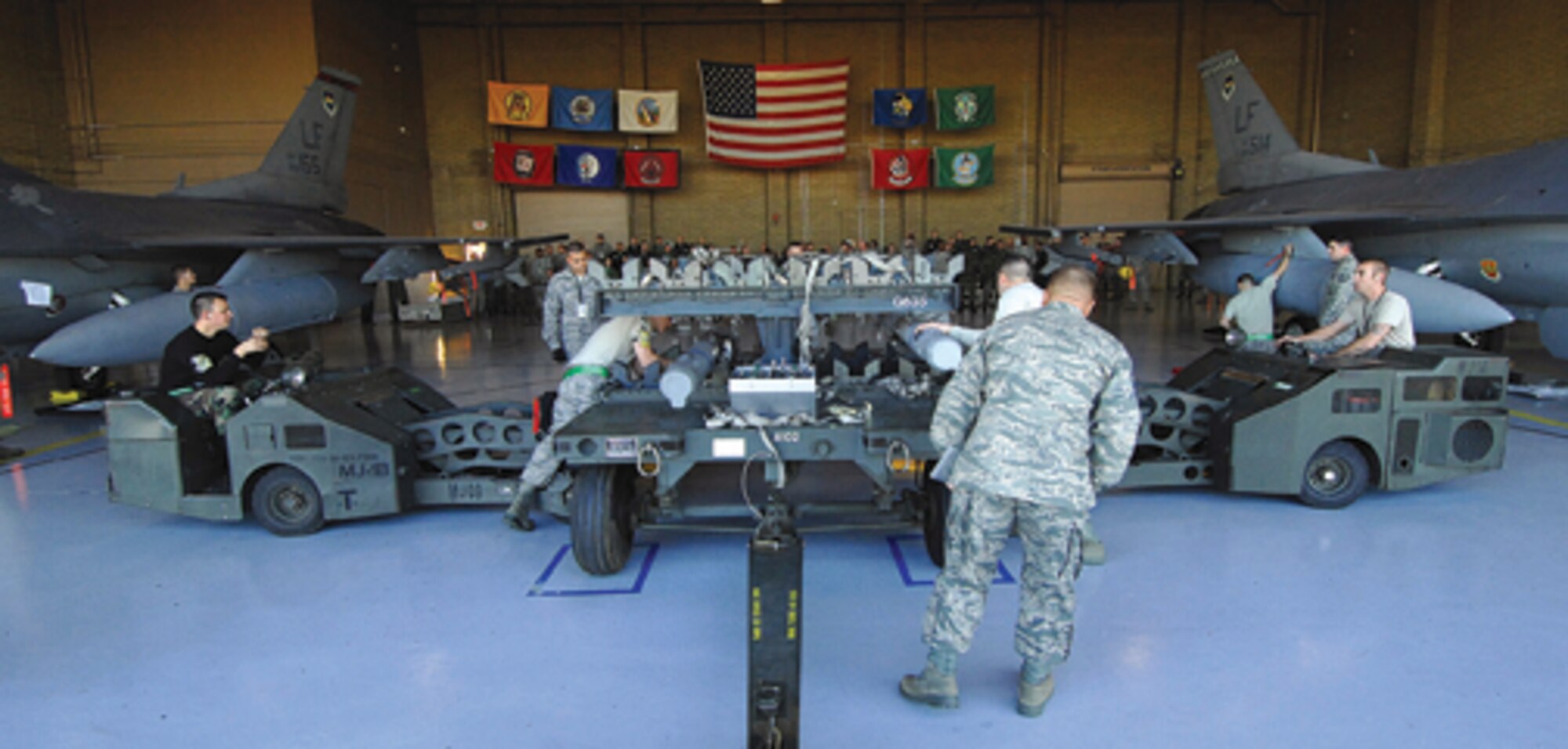 Members of the 310th Aircraft Maintenance Unit (left) and 308th AMU compete during the Luke Air Force Base quarterly load crew competition Feb. 13 at Bldg. 485. (U.S. Air Force photo/ Tech. Sgt. Jeffery Wolfe)