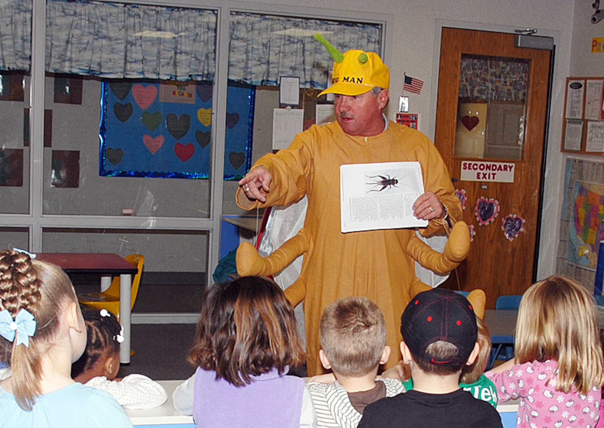 “Tommy the Termite” answers questions about crickets from children in the Vance Child Development Center’s pre-school class during a Feb. 19 visit. Tommy the Termite, portrayed by Richard Johndrow with the CSC Entomology division, asked the children if they had seen his cousin, “Carl the Cricket.” The children are doing a unit on crickets, so Tommy the Termite explained how crickets live and how soon the children can expect to see the bugs. (U.S. Air Force photo by Angie Roche)