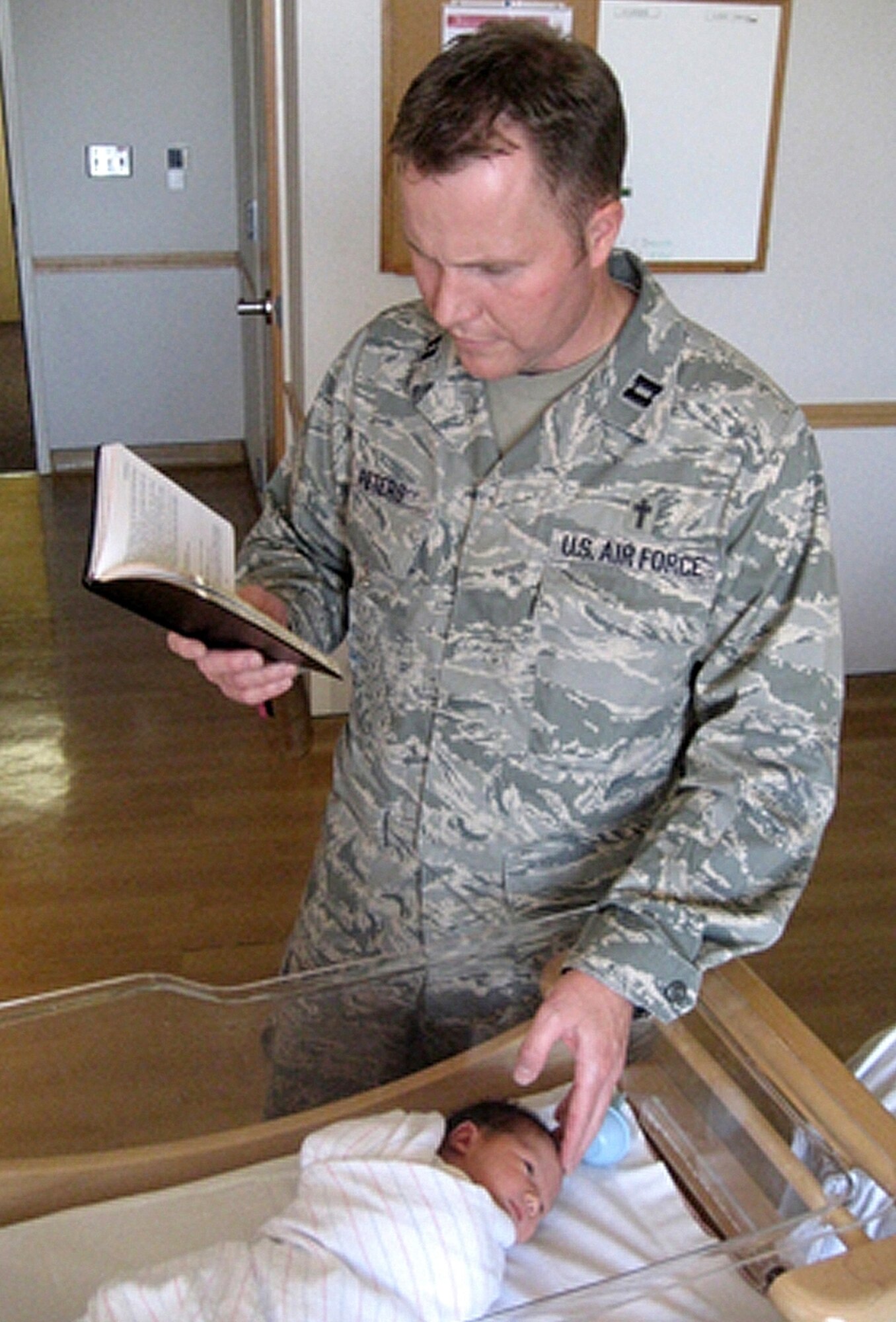Chaplain (Capt.) Jason Peters welcomes a new life by offering a blessing following a delivery at Wilford Hall Medical Center in October 2008. The 59th Medical Center Chapel staff received the 2008 Air Education and Training Command Outstanding Chaplain Corps Team Award, Medium Chapel Organization. (U.S. Air Force photo)