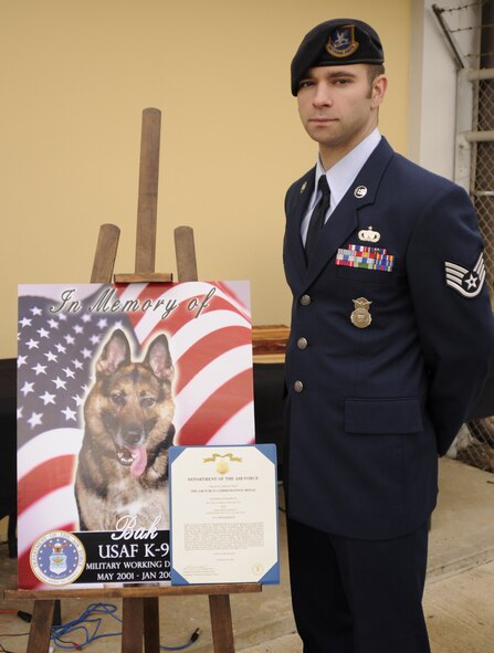 Staff Sgt. Chris Smith, 39th Security Forces Squadron military working dog handler, stands with a memorial sign of the late MWD, Bak, Feb. 20 at the MWD memorial ceremony at the 39 SFS K-9 kennels.  Bak passed Jan. 27 after working as a patrol/explosive detector dog at Incirlik for more than five years. (U.S. Air Force photo by Airman 1st Class Amber Russell)