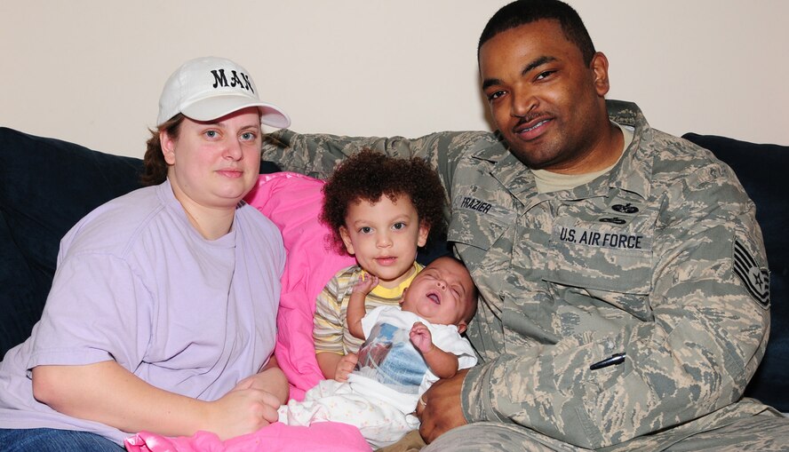 Mandy, left, Barry Frazier III, second left, Alexis and Tech. Sgt. Barry Frazier, 100th Air Refueling Wing Legal Office, pose for a family photo at home Feb. 19. Baby Alexis, 5 1/2 months, weighs 8 pounds, 4 ounces. She was one of premature twins born Sept. 6, 2008. Her twin brother, Eric, sadly died Dec. 10. The twins weren't due until Jan. 1 and were born at just 23 weeks, three days gestation period. Alexis was 1 pound 3 ounces at birth, and Eric was 1 pound, 5 ounces. Eric's memory lives on in the Frazier household -- Alexis has a photo of him on her T-shirt (worn in this photo) and the family has a huge photo of him on their wall at home. (U.S. Air Force photo by Karen Abeyasekere)