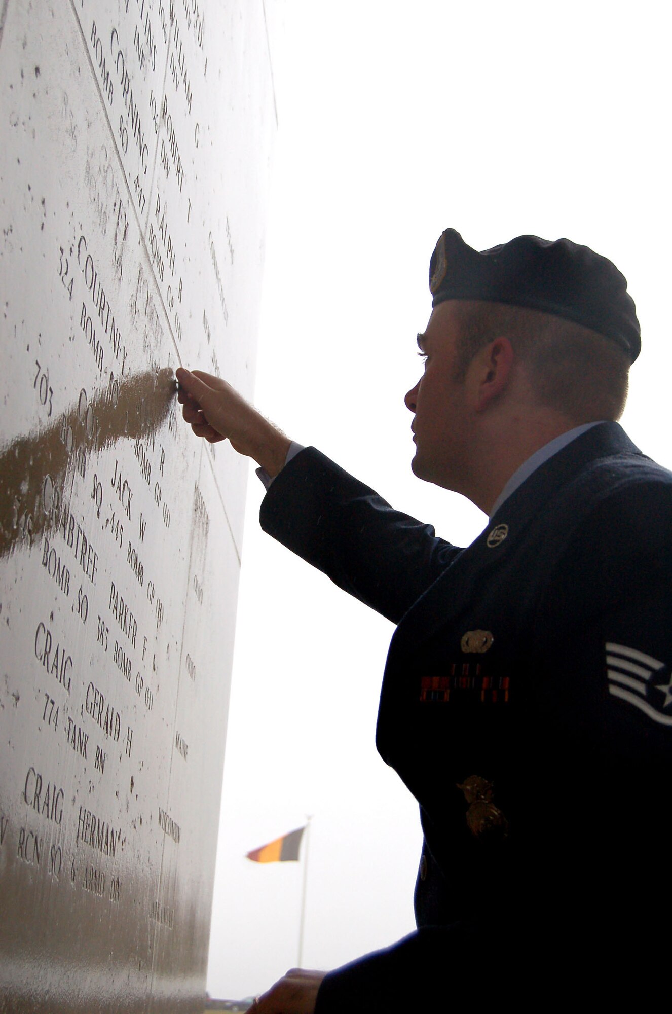 HENRI-CHAPELLE, Belgium -- Staff Sgt. Ralph Bunnell, security guard for the NATO Programming Centre, places a rosette next to Staff Sgt. Robert L. Cotey’s name Feb. 20, 2009 at the Henri-Chapelle Cemetery and Memorial in Belgium, signifying he is no longer missing in action. Sergeant Cotey was a Missouri native and one of nine men with the McMurray Crew in the Army Air Corps, who flew a B-24 bomber during World War II. (U.S. Air Force photo by 2nd Lt. Kathleen Polesnak)