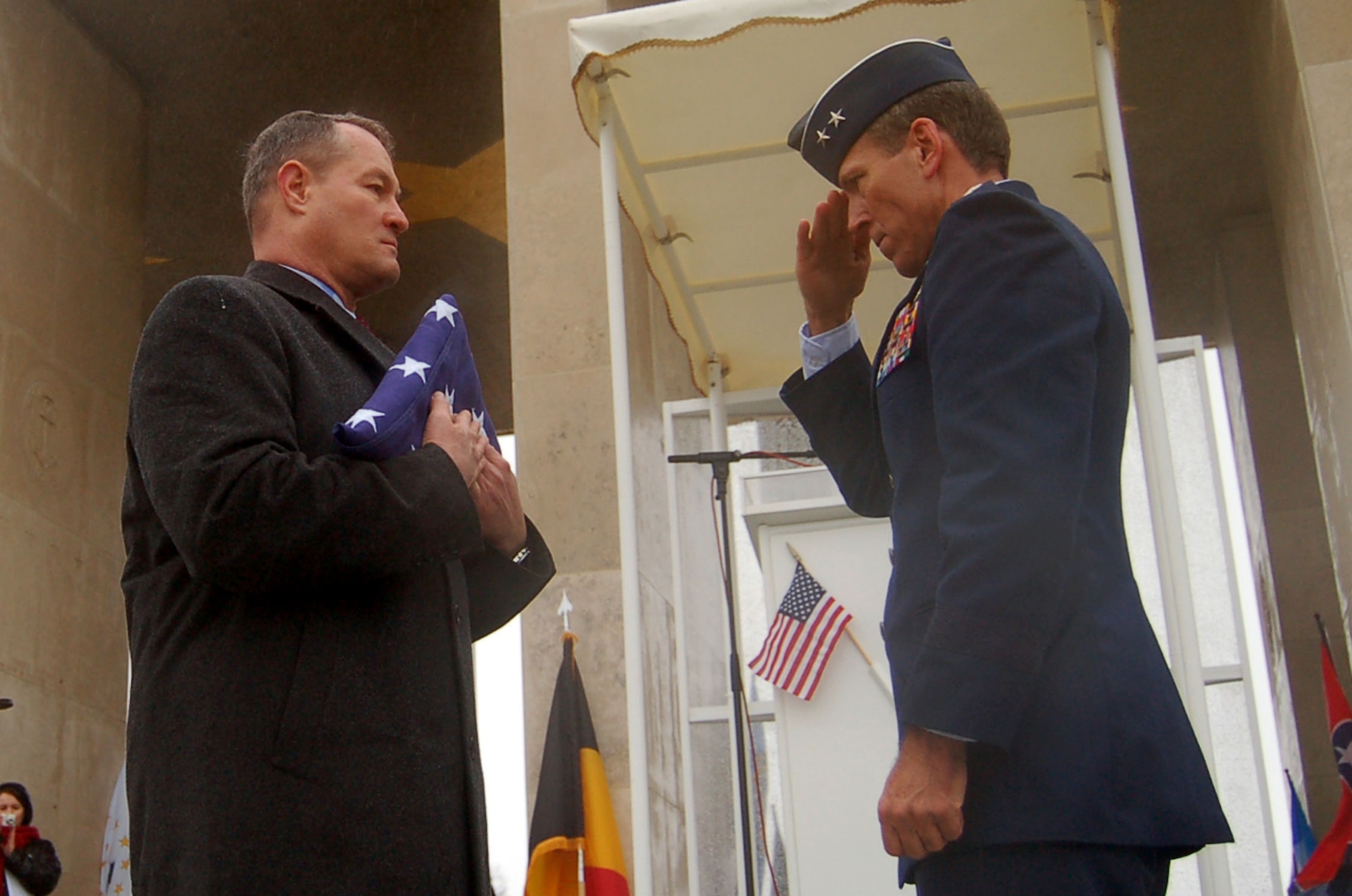 HENRI-CHAPELLE, Belgium -- Maj. Gen. Thomas B. Wright, operations deputy chief of staff of operations for Supreme Headquarters Allied Powers Europe, NATO, salutes a folded flag held by U.S. Army Retired Brig. Gen. Steven R. Hawkins, director of the European region for the American Battle Monuments Commission, to pay respects Feb. 20, 2009, to the nine fallen Airmen of the McMurray Crew in the Army Air Corps, who are no longer missing in action. The B-24 bomber crew’s remains were discovered after more than 60 years in a field southwest of Berlin. (U.S. Air Force photo by 2nd Lt. Kathleen Polesnak)