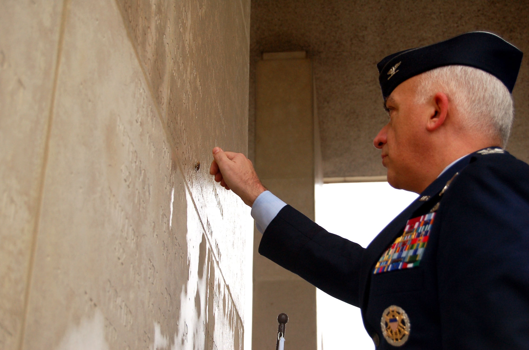 HENRI-CHAPELLE, Belgium -- Col. Mark Horn, U.S. National Military Representative to Supreme Headquarters Allied Powers Europe, places a rosette by 1st Lt. Raymond Pascuel's name Feb. 20, 2009 at the Henri-Chapelle Cemetery and Memorial in Belgium, signifying he is no longer missing in action. Lieutenant Pascuel was a New York native and one of nine men with the McMurray Crew in the Army Air Corps, who flew a B-24 bomber during World War II. (U.S. Air Force photo by 2nd Lt. Kathleen Polesnak)