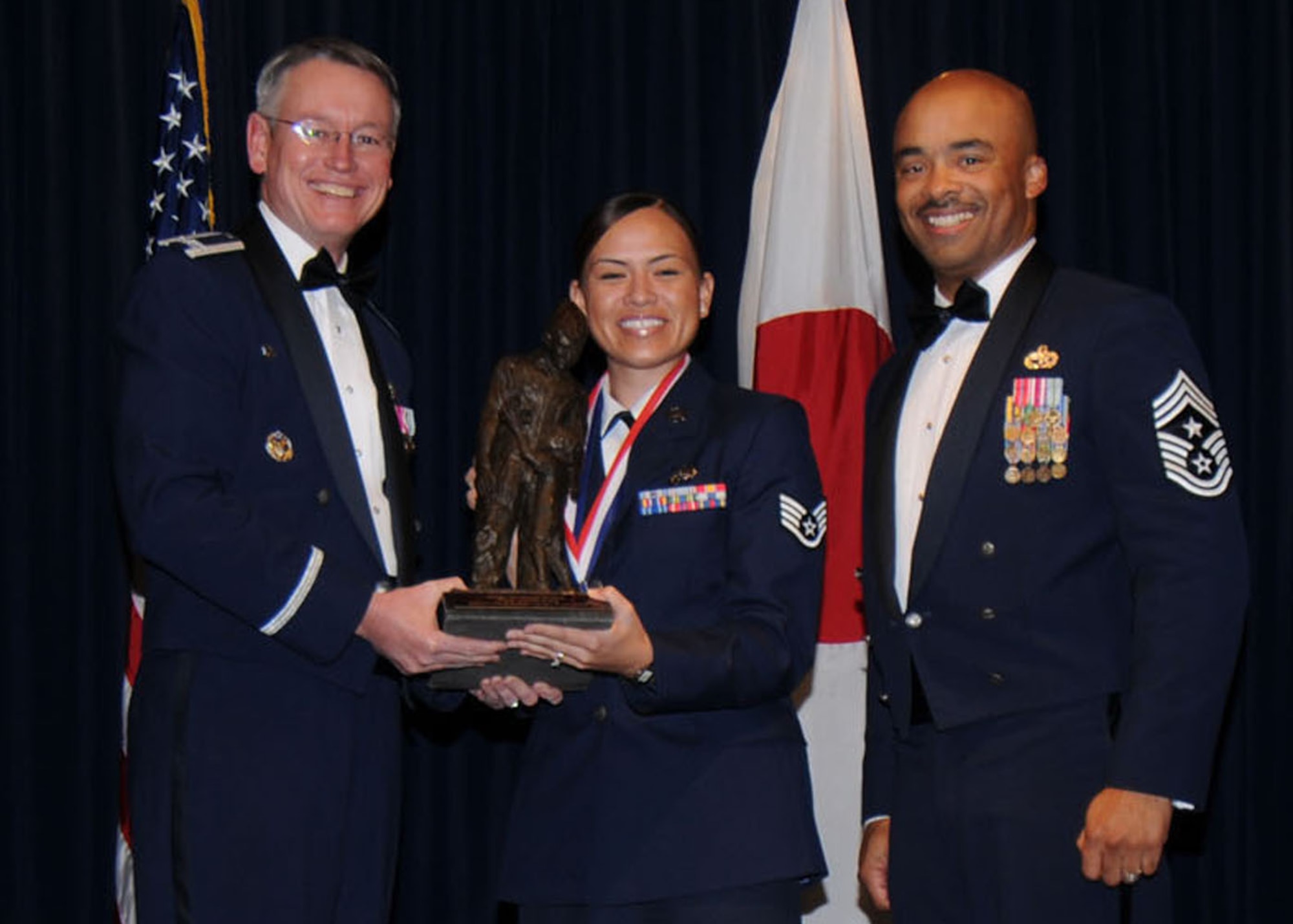 YOKOTA AIR BASE, Japan -- Colonel Jeff Newell, 374th Airlift Wing commander, and Chief Master Sgt. Linus Jordan, 374th AW command chief master sergeant, present Staff Sgt. Melissa Keith, center, with the Honor Guardsmen of the Year award Feb. 21. Sergeant Keith is assigned to the 374th Communications Squadron. (U.S. Air Force photo/Senior Airman Veronica Pierce)
