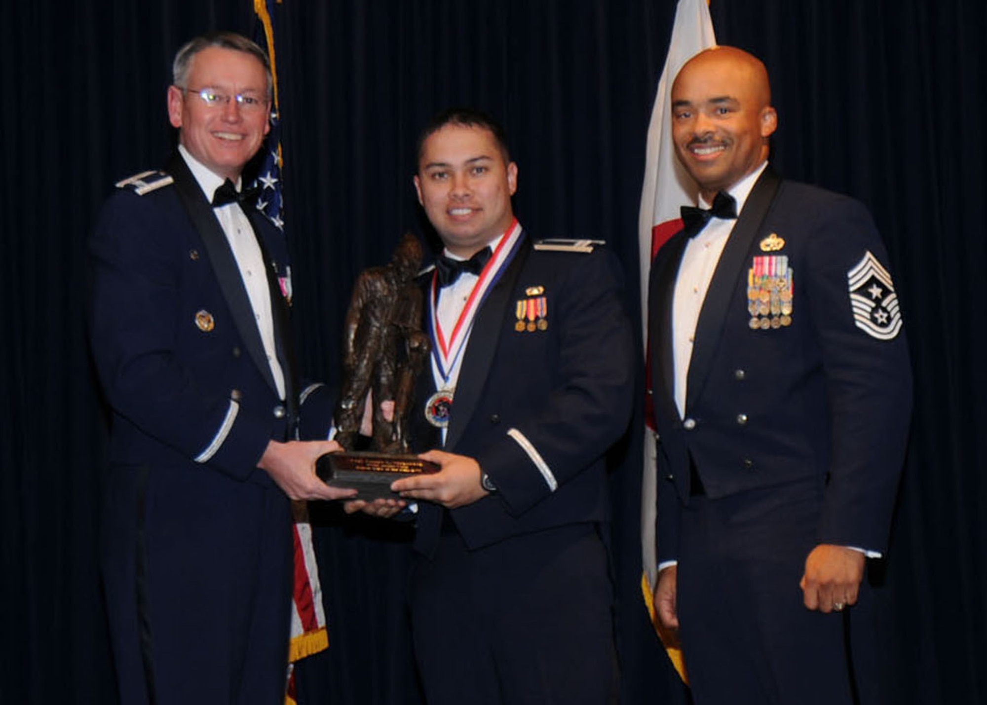 YOKOTA AIR BASE, Japan -- Colonel Jeff Newell, 374th Airlift Wing commander, and Chief Master Sgt. Linus Jordan, 374th AW command chief master sergeant, present Capt. Joseph L. Maguadog, center, with the Company Grade Officer of the Year award for tenant unit organizations Feb. 21. Captain Maguadog is assigned to the Department of Defense Special Representatives Japan. (U.S. Air Force photo/Senior Airman Veronica Pierce)
 
