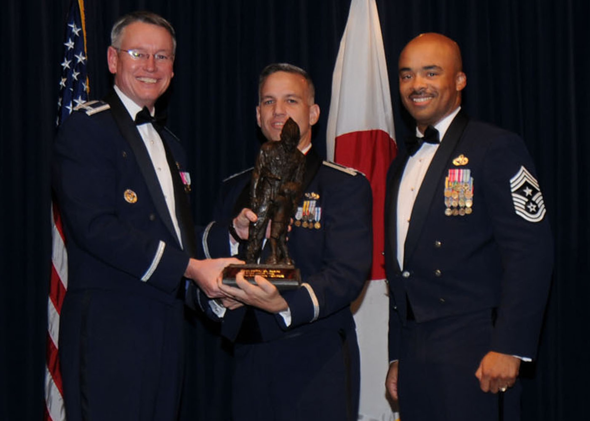 YOKOTA AIR BASE, Japan -- Colonel Jeff Newell, 374th Airlift Wing commander, and Chief Master Sgt. Linus Jordan, 374th AW command chief master sergeant, present Capt. Jeffery Beard, center, with the 374th AW Company Grade Officer of the Year award Feb. 21. Captain Beard is assigned to the 374th Maintenance Squadron.  (U.S. Air Force photo/Senior Airman Veronica Pierce)

 
