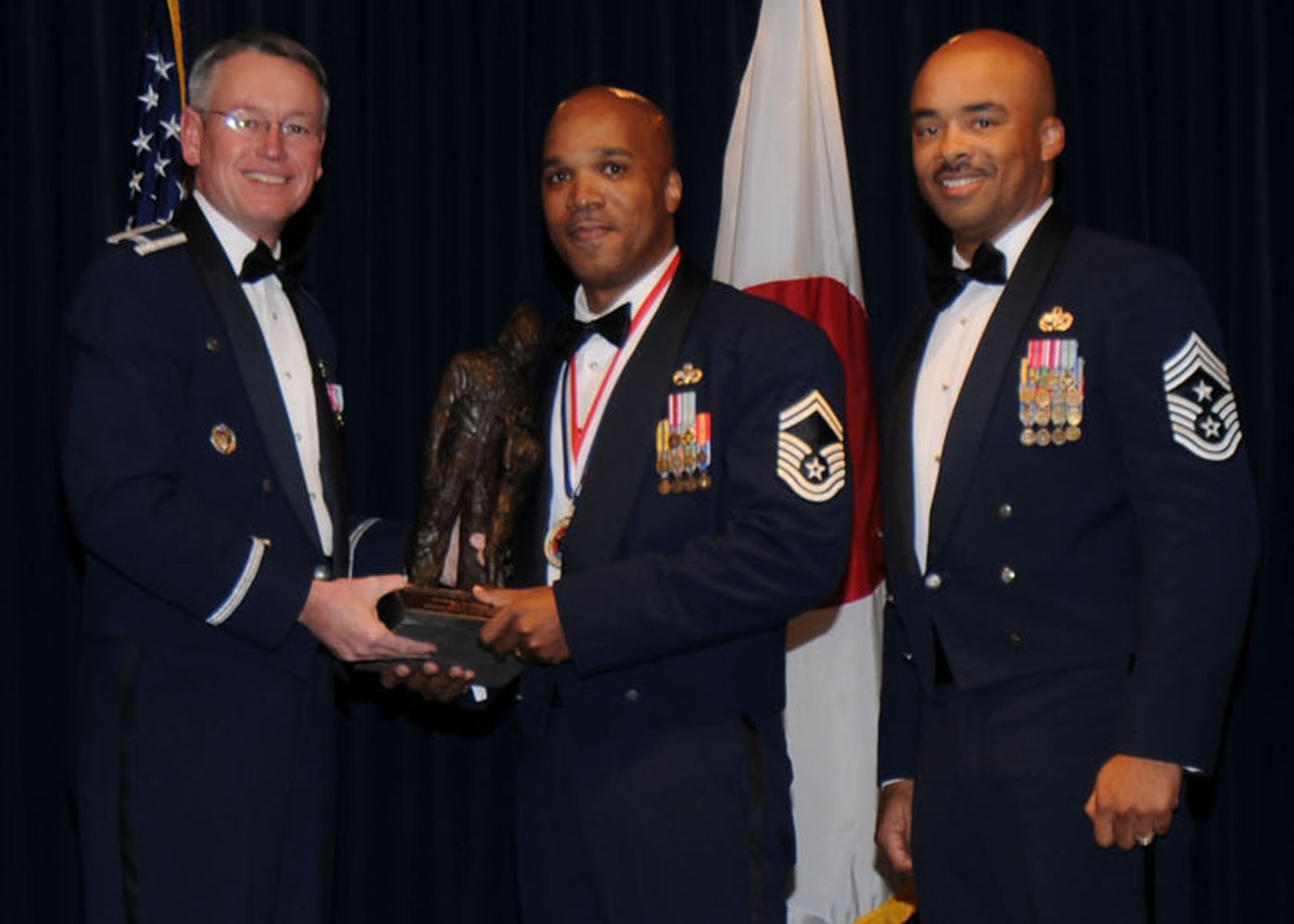 YOKOTA AIR BASE, Japan -- Colonel Jeff Newell, 374th Airlift Wing commander, and Chief Master Sgt. Linus Jordan, 374th AW command chief master sergeant, present Senior Master Sgt. Derrick Mobley, center, with the Senior NCO of the Year award for tenant unit organizations Feb. 21. Sergeant Mpbley is assigned to the 730th Air Mobility Squadron. (U.S. Air Force photo/Senior Airman Veronica Pierce)
