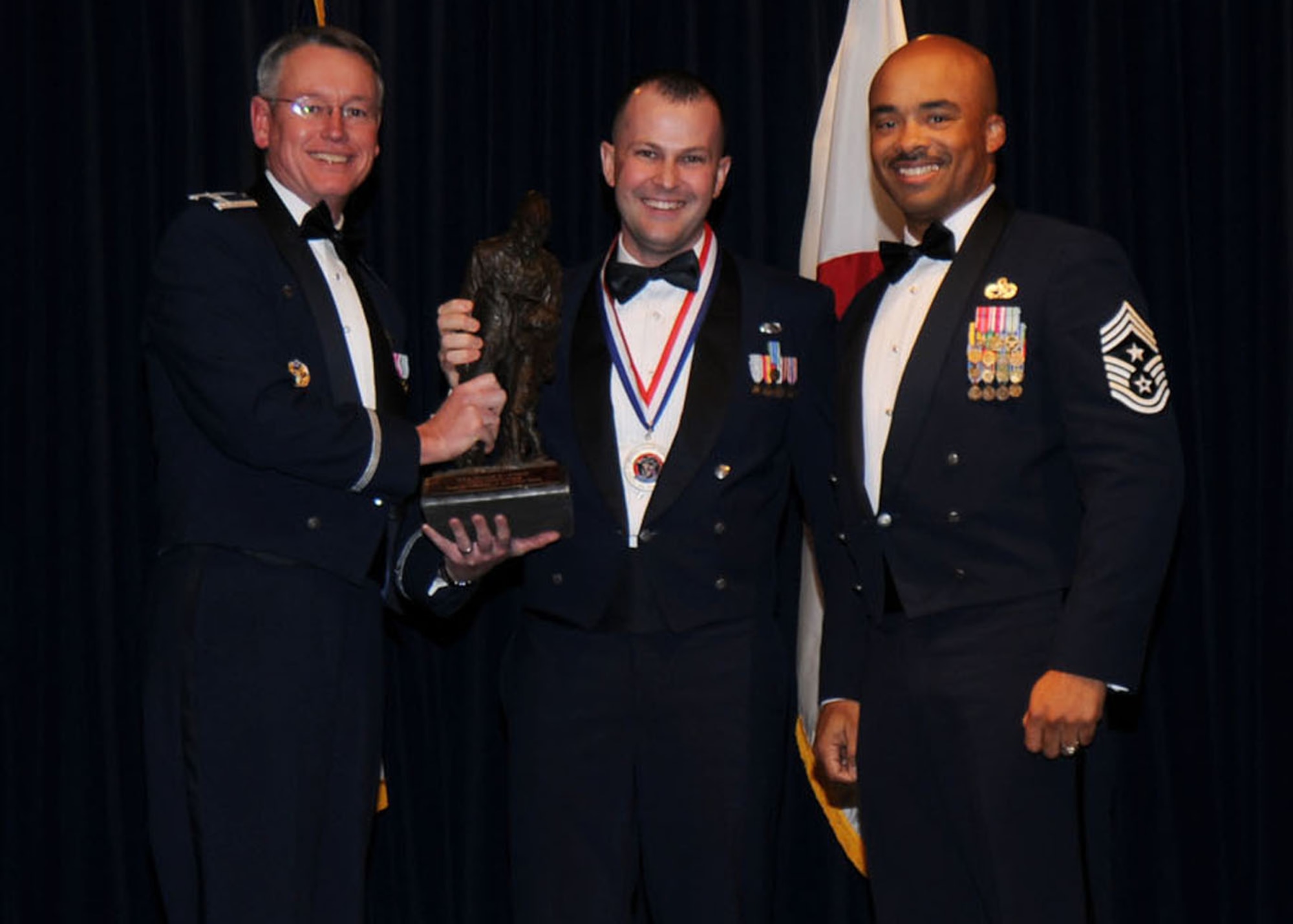 YOKOTA AIR BASE, Japan -- Colonel Jeff Newell, 374th Airlift Wing commander, and Chief Master Sgt. Linus Jordan, 374th AW command chief master sergeant, present Senior Airman David L. Clark, center, with the Airman of the Year award for tenant unit organizations Feb. 21. Airman Clack is assigned to the Armed Forces Network- Tokyo. (U.S. Air Force photo/ Senior Airman Veronica Pierce)

