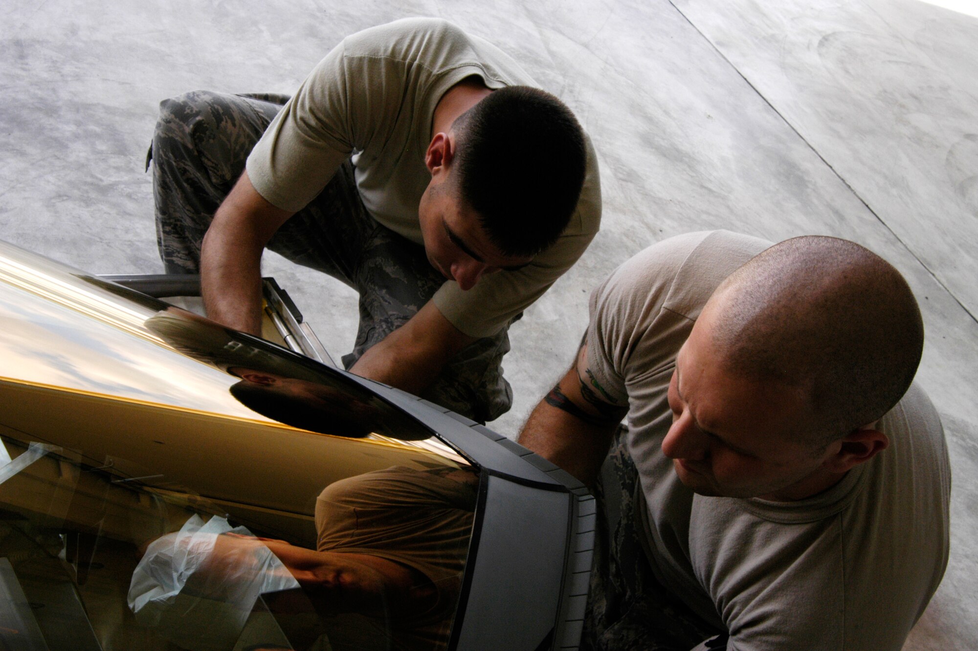 Senior Airman Ryan Ott and Staff Sgt. Tim Sullivan,  36th Expeditionary Maintenance Squadron F-22 Egress and Systems specialists, prepare an  F-22 canopy for installation at Andersen Air Force Base Feb. 18, 2008.  Members of the Expeditionary Fighter Squadron and the 36th Expeditionary Maintenance are deployed out of Elmendorf Air Force Base, Alaska, with more than 250 Airmen in support of the Pacifics Theater Security Package.(U.S. Air Force photo by Senior Airman Ryan Whitney)                                