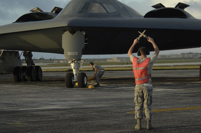 (foreground) Staff Sgt. Kyle Helton marshals in a B-2 Spirit while Airman 1st Class Patrick Holter places chalks Feb. 23 after arriving at Andersen Air Force Base, Guam. More than 250 Airmen and four B-2 Spirits, 509th Bomb Wing, 13th Bomb Squadron Whiteman Air Force Base, Mo., began arriving here to replace the 23rd Expeditionary Bomb Squadron and its B-52 Stratofortress as the Pacific regions Continuous Bomber Presence. Both Airmen are from the 36th Expeditionary Maintenance Squadron.

(U.S. Air Force photo/ Master Sgt. Kevin J. Gruenwald,)