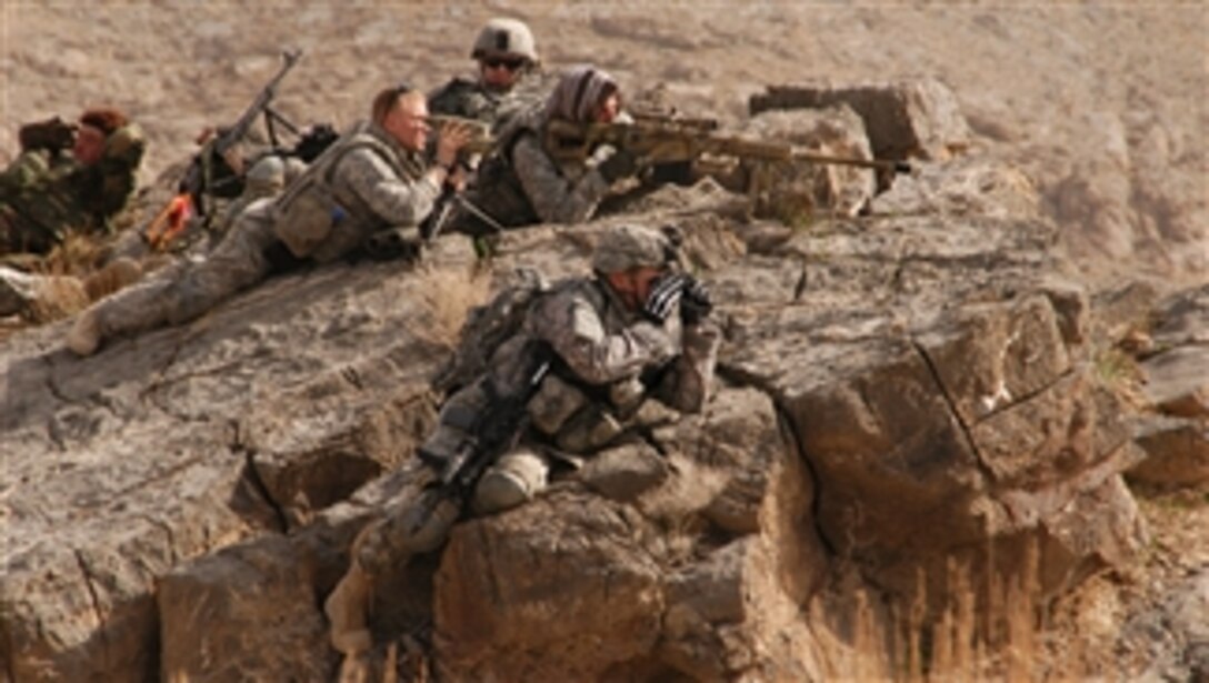 U.S. Army 1st Lt. Patrick Higgins (foreground) of 1st Battalion, 4th Infantry Regiment surveys a village as Spc. Aaron Trapley and Sgt. Gary Fordyce provide sniper overwatch and Sgt. Nicholas Gauthier provides security during a foot patrol near Forward Operating Base Mizan, Afghanistan, on Feb. 23, 2009.  