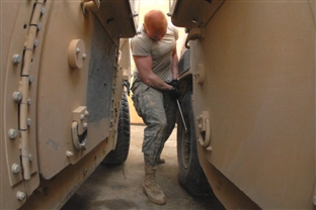 U.S. Army Pvt. Bryce Vittetoe tightens a lug nut to a tire while performing after-mission maintenance on his Humvee on Forward Operating Base Lane, Zabul province, Afghanistan,  Feb. 22, 2009. Bryce is assigned to Company B, 1st Battalion, 4th Infantry Regiment.