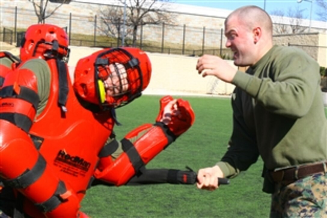 U.S. Marine Corps Cpl. David Chancellor, a guard at Marine Barracks Washington, confronts two simulated adversaries after being sprayed with oleoresin capsicum pepper spray during nonlethal tactics training at Marine Barracks Washington, D.C., Feb. 17, 2009. Chancellor, among others, qualified as a user and instructor of pepper spray.