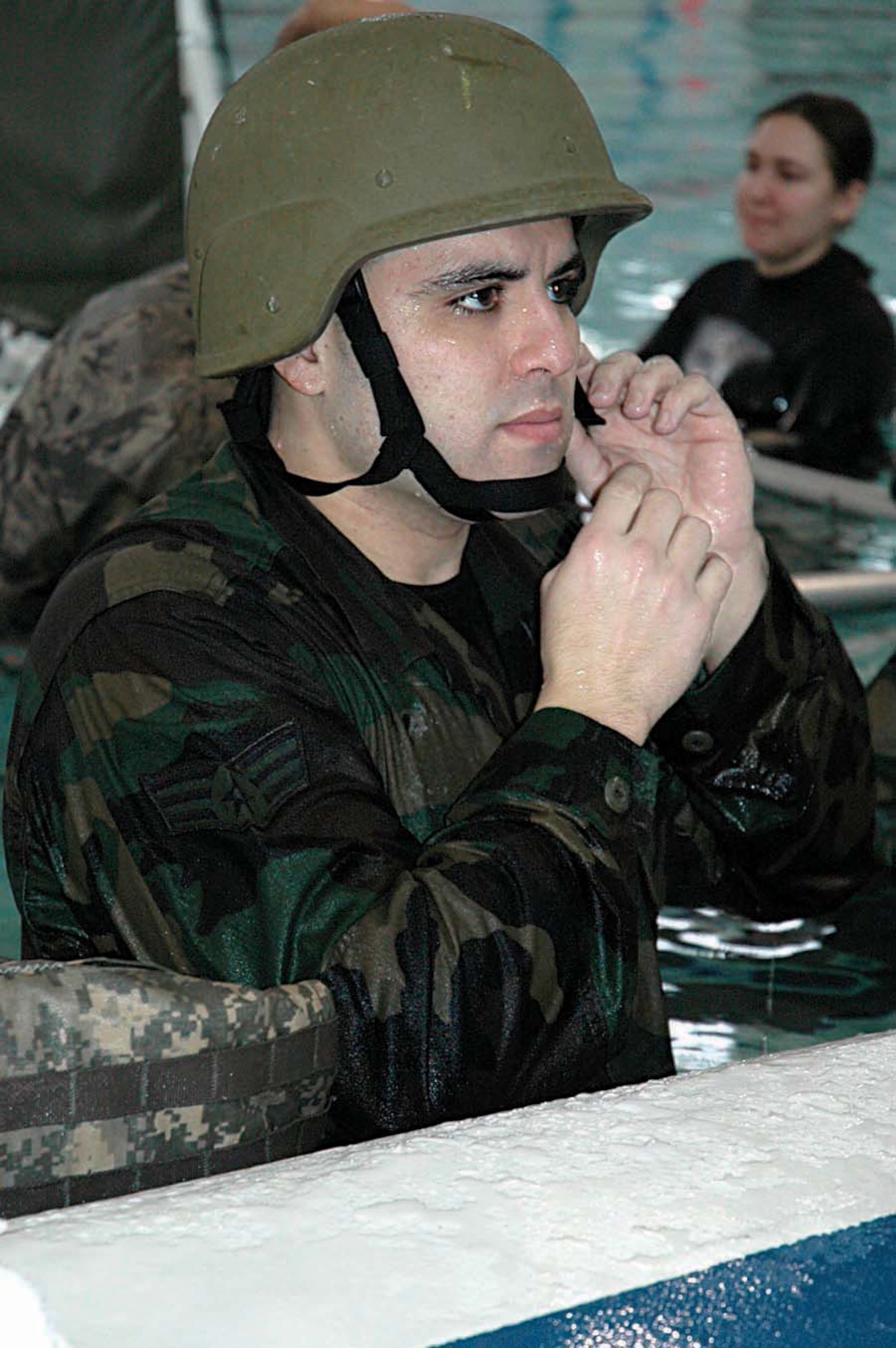 Staff Sgt. Freddie Garza, a Reservist with the 446th Security Forces Squadron, McChord Air Force Base, Wash., dons his Kevlar helment in preparation for Humvee rollover training Feb. 8 at Fort Lewis, the nearby Army post.  As part of the rollover training, security forces Reservists were dunked into water, blindfolded, and had to navigate out of one of two simulated Humvee doors. (U.S. Air Force photo/Airman First Class Patrick Cabellon)