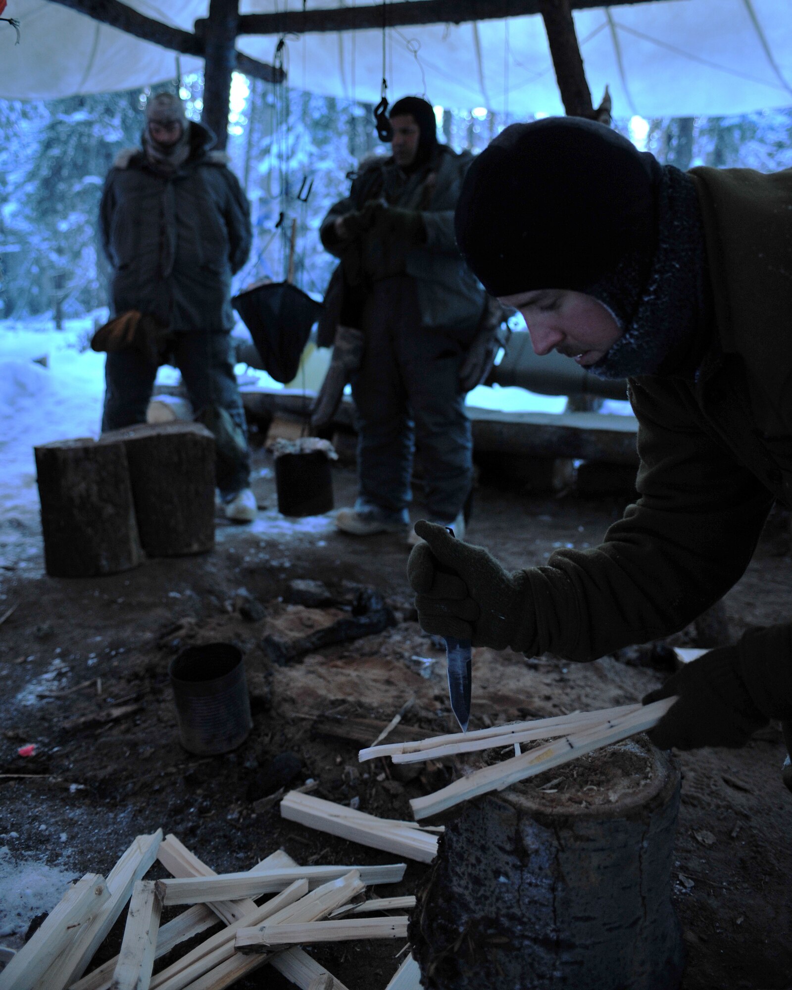 Senior Airman Chris Walsh, Detachment 1, 66th Training Squadron, Arctic Survival Instructor, splits wood Jan. 28, 2009, Eielson Air Force Base, Alaska. The split wood burns faster and makes starting a fire easier than other types of wood. (U.S. Air Force photo/Airman 1st Class Willard E. Grande II)