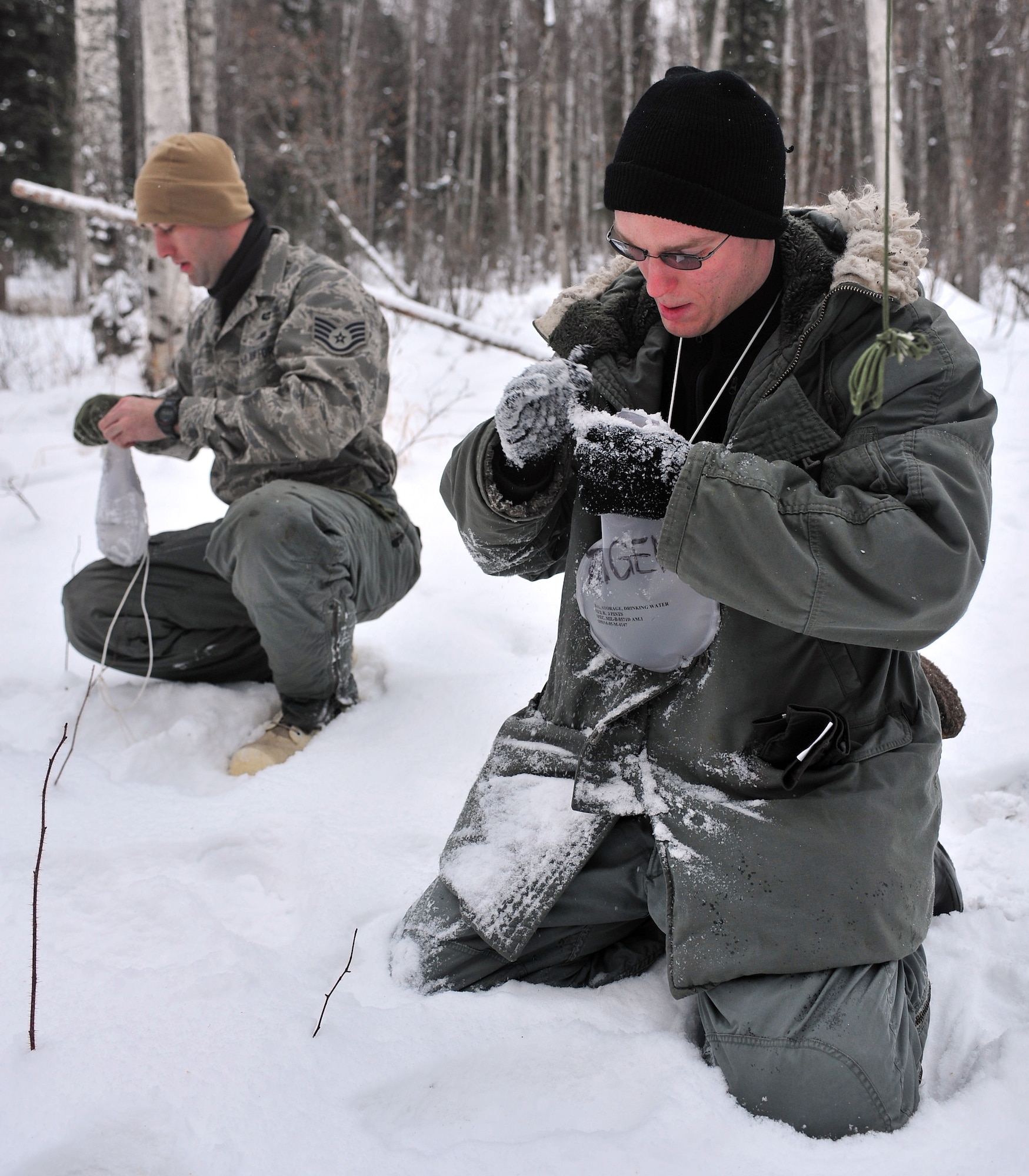 Airmen attending Arctic Survival School fill their water bottles with snow Feb. 25, 2009, Eielson Air Force Base, Alaska. Body heat will melt the snow, providing a perpetual water source. (U.S. Air Force photo/Airman 1st Class Willard E. Grande II)