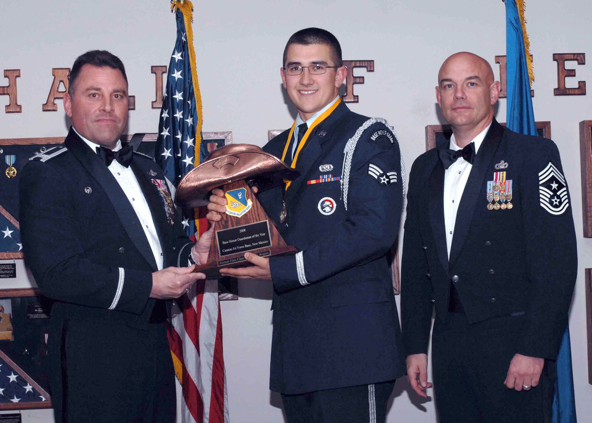 CANNON AIR FORCE BASE, N.M. --  Senior Airman Nathan Rogers, 27th Special Operations Logistics Readiness Squadron, receives the Honor Guardsman of the Year award from (left) Col. Timothy Leahy, 27th Special Operations Wing commander, and (right) Chief Master Sgt. Daniel Fischer, wing command chief. The wing's top Airmen and civilians were recognized at an annual awards dinner at The Landing on Feb. 21. (U.S. Air Force photo/ Airman 1st Class James Bell)