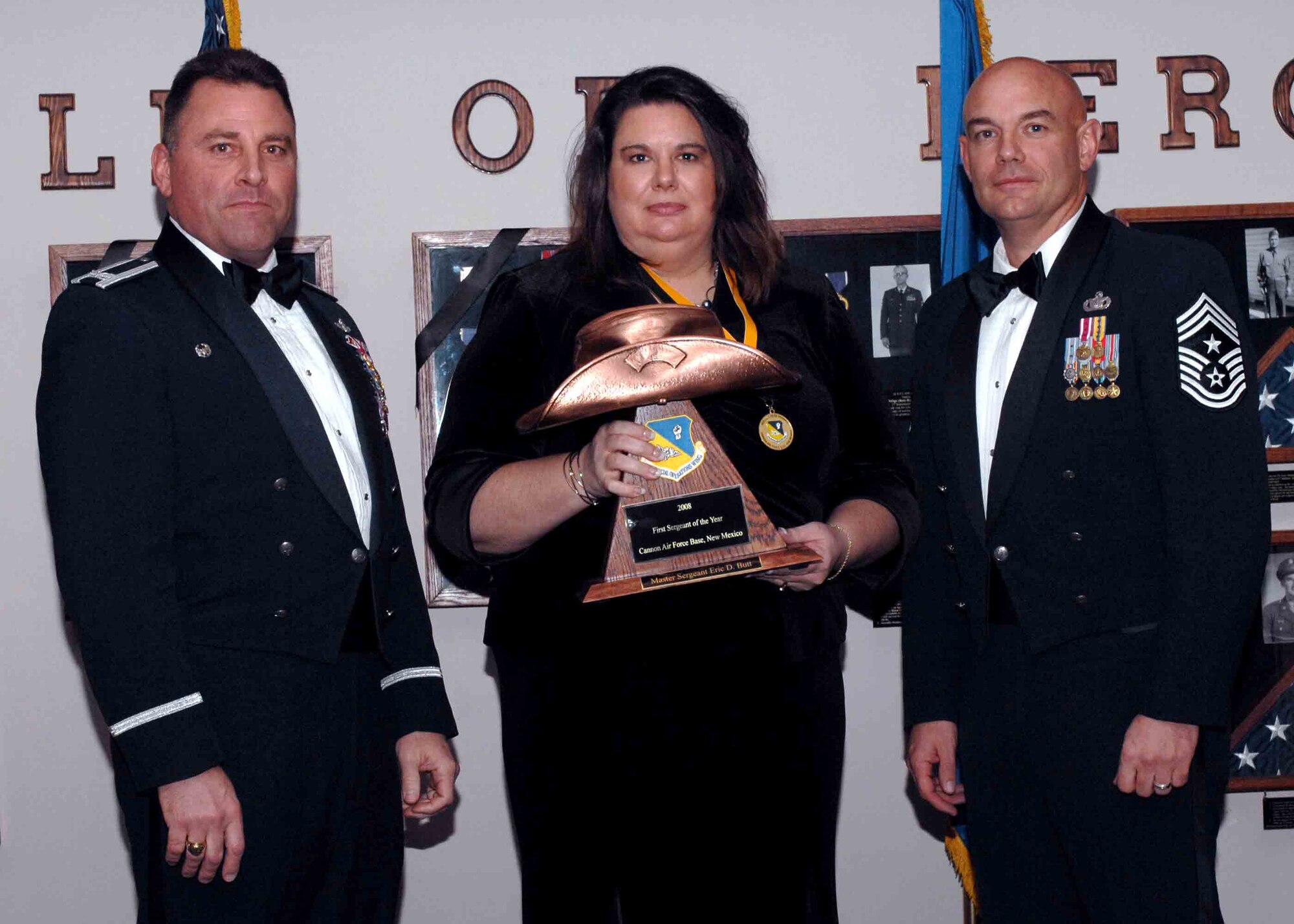 CANNON AIR FORCE BASE, N.M. -- Shannon Butt, on behalf of her husband Master Sgt. Eric Butt, 27th Special Operations Medical Group, receives the First Sergeant of the Year award from (left) Col. Timothy Leahy, 27th Special Operations Wing commander and (right) Chief Master Sgt. Daniel Fischer, wing command chief. The wing?s top Airmen and civilians were recognized at an annual awards dinner at The Landing on Feb. 21. (U.S. Air Force photo/Airman 1st Class James Bell)