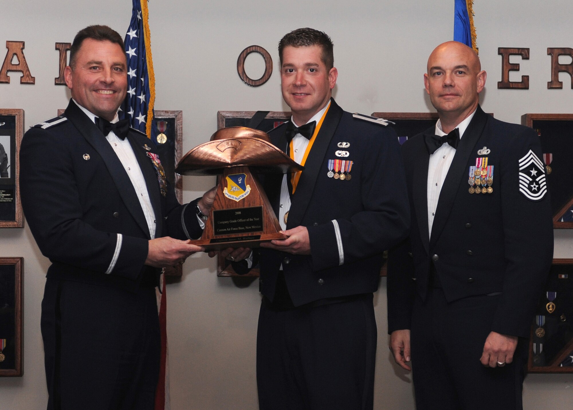 CANNON AIR FORCE BASE N.M.- Capt. Jason Wallace, 27th Special Operations Maintenance Operations Squadron, receives the Company Grade Officer of the Year award from (left) Col.Timothy Leahy, 27th Special Operations Wing commander, , and (right) Chief Master Sgt. Daniel Fischer, wing command chief. The wing's top Airmen and civilians were recognized at the annual awards dinner at The Landing Feb. 21. (U.S. Air Force photo/Airman 1st Class Evelyn Chavez)  
