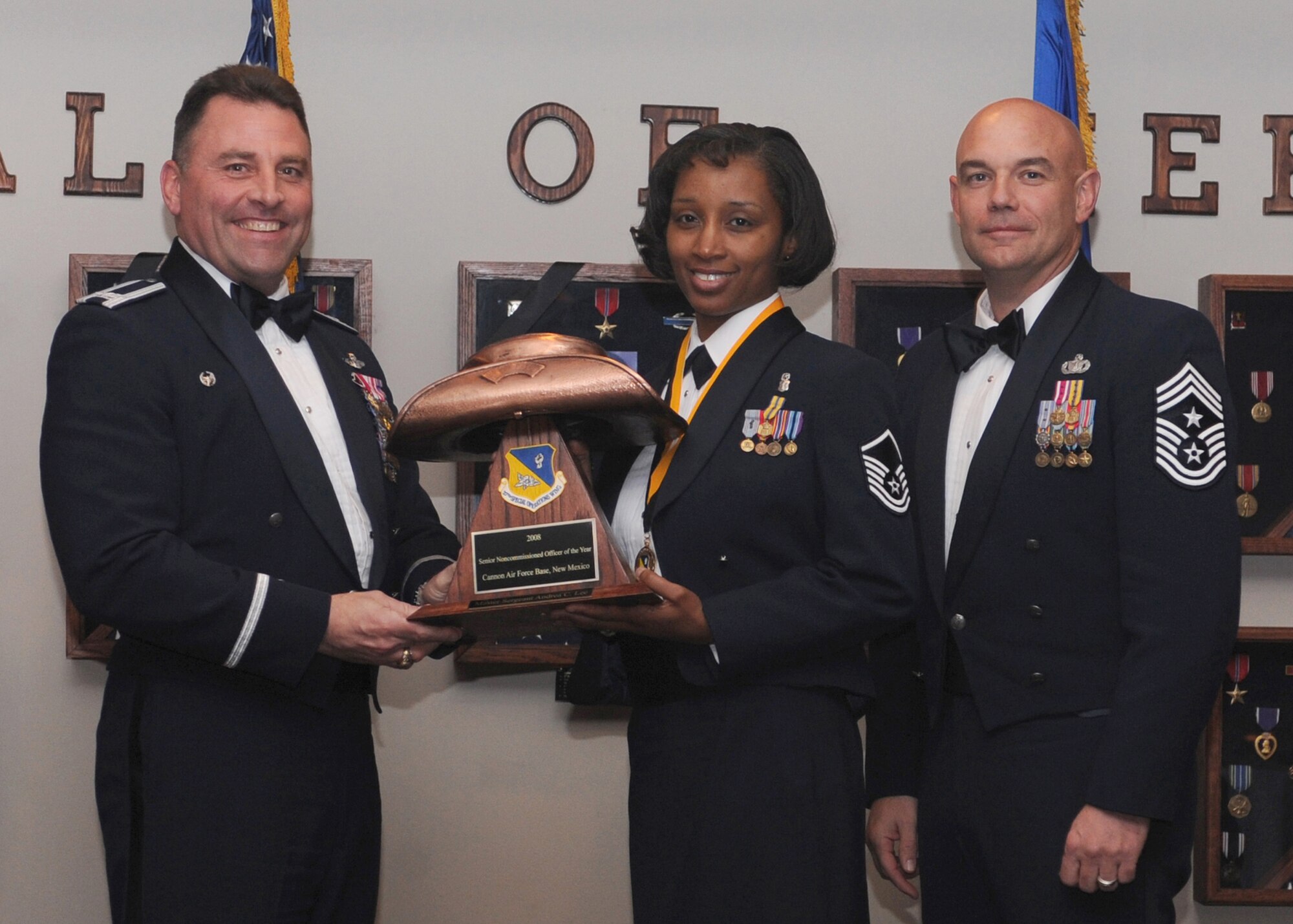 CANNON AIR FORCE BASE, N.M. -- Master Sgt. Andrea Lea, 27the Special Operations Medical Group, receives the Senior Non-commissioned Officer of the Year award from (left) Col. Timothy Leahy, 27th Special Operations Wing commander, and (right) Chief Master Sgt. Daniel Fischer, wing command chief. The wing's top Airmen and civilians were recognized at the annual awards dinner at The Landing Feb. 21. (U.S. Air Force photo/Airman 1st Class Evelyn Chavez) 