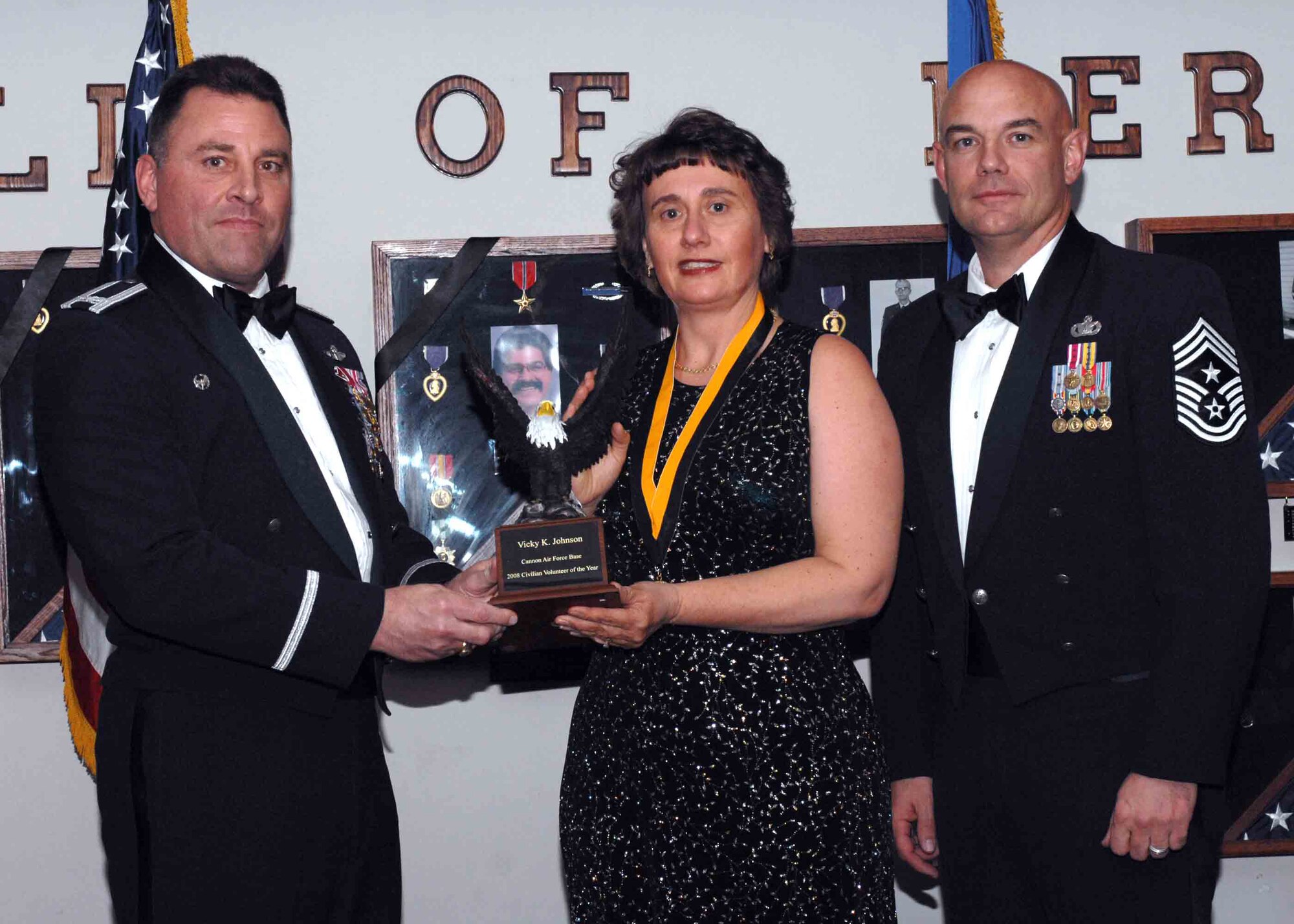 CANNON AIR FORCE BASE, N.M. -- Lt. Col. Vicky Johnson, 27th Special Operations Group, receives the Family Member Volunteer of the Year award from (left) Col. Timothy Leahy, 27th Special Operations Wing commander and (right) Chief Master Sgt. Daniel Fischer, wing command chief. The wing?s top Airman and civilians were recognized at an annual awards dinner at The Landing on Feb. 21.  (U.S. Air Force Photo/Airman 1st Class James R. Bell)