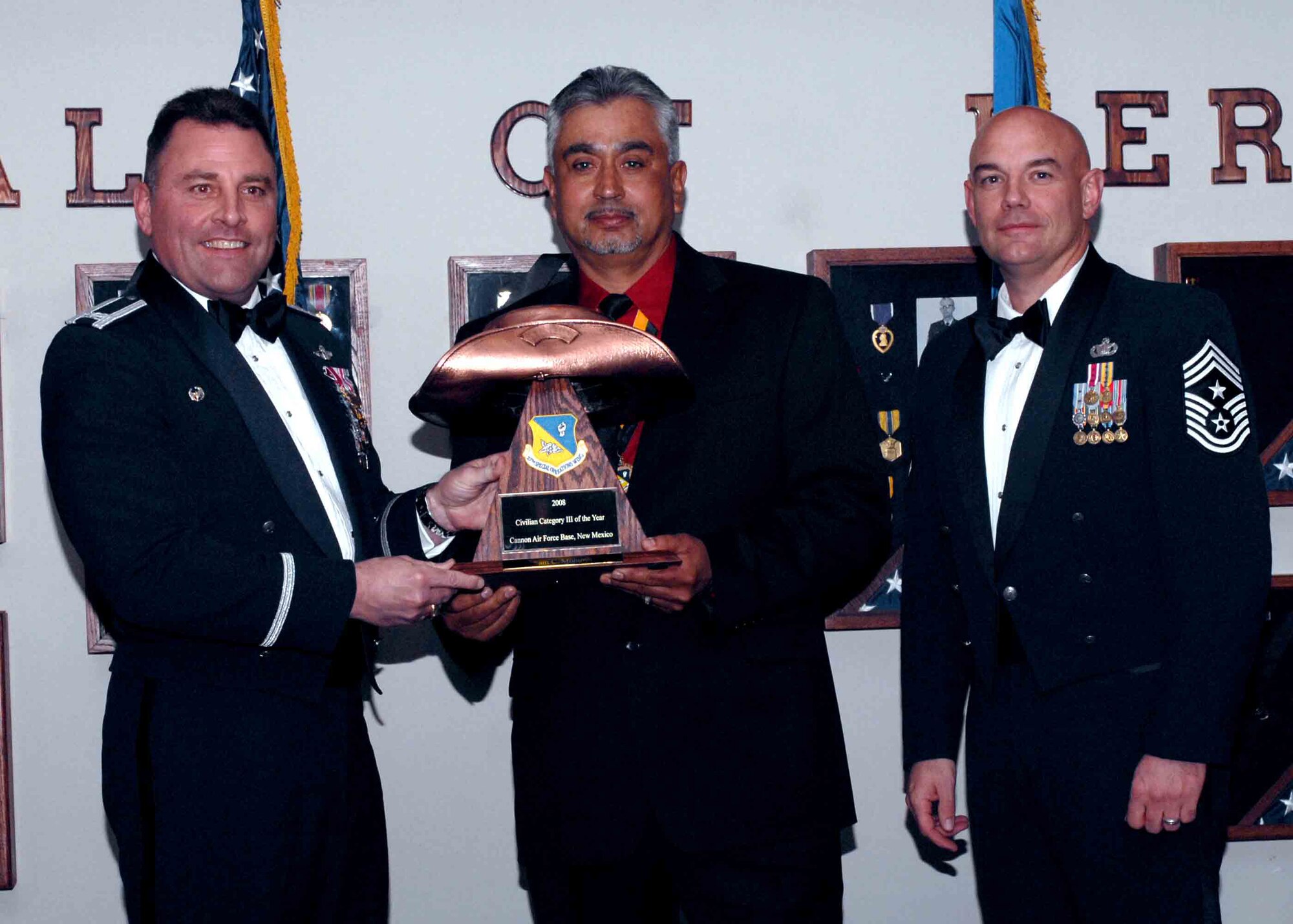 CANNON AIR FORCE BASE, N.M. ? Sam Montoya, from the 27th Special Operations Mission Support Group, receives the Category III Civilian of the Year award from  (left) Col. Timothy Leahy, 27th Special Operations Wing commander, and (right) Chief Master Sgt. Daniel Fischer, wing command chief. The wing?s top Airmen and civilians were recognized at an annual awards dinner at The Landing on Feb. 21. (U.S. Air Force photo/Airman 1st Class James Bell)