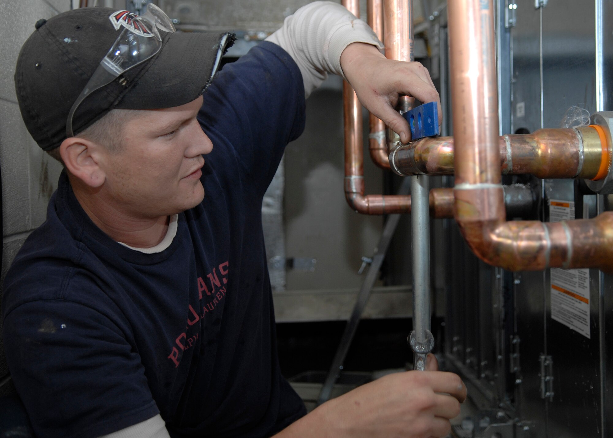 Rob Smith levels the supply and return lines for part of a heating, ventilation and air conditioning system Feb. 18 on Charleston AFB. There are currently four HVAC installation projects taking place at different facilities where outdated, inefficient heating and cooling equipment is being replaced with new, energy-efficient equipment and controls to help the base conserve energy. Mr. Smith is a plumber working for Cullum Mechanical. (U.S. Air Force photo/Senior Airman Katie Gieratz)