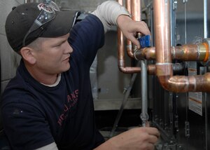 Rob Smith levels the supply and return lines for part of a heating, ventilation and air conditioning system Feb. 18 on Charleston AFB. There are currently four HVAC installation projects taking place at different facilities where outdated, inefficient heating and cooling equipment is being replaced with new, energy-efficient equipment and controls to help the base conserve energy. Mr. Smith is a plumber working for Cullum Mechanical. (U.S. Air Force photo/Senior Airman Katie Gieratz)