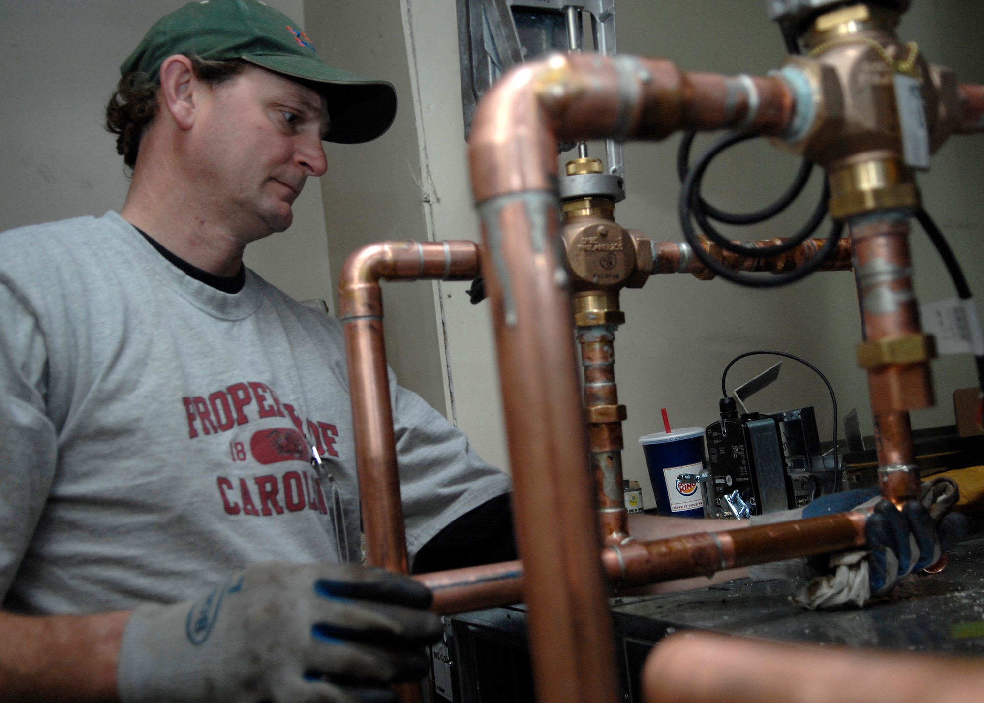 Johnny Radcliffe wipes the copper pipes down to cool and set the soldering for a heating, ventilation and air conditioning system Feb. 18 on Charleston AFB. There are currently four HVAC installation projects taking place at different facilities where outdated, inefficient heating and cooling equipment is being replaced with new, energy-efficient equipment and controls to help the base conserve energy. Mr. Radcliffe is a foreman working for Cullum Mechanical. (U.S. Air Force photo/Senior Airman Katie Gieratz)