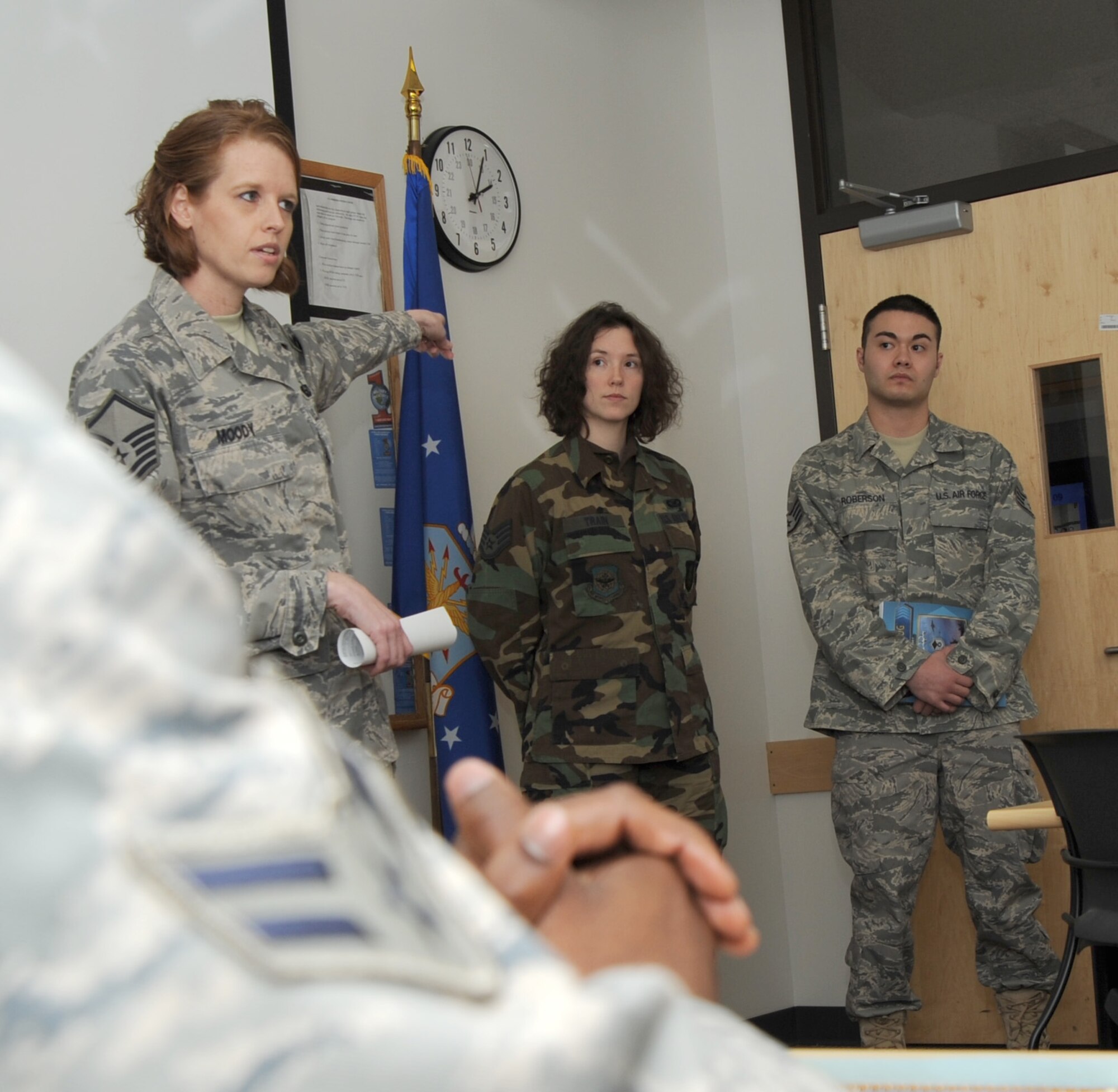 MCCONNELL AIR FORCE BASE, Kan. -- Master Sgt. Heather Moody, 22nd Force Support Squadron, uses First Term Airmen Center instructors Staff Sgts. Jamie Train, 22nd Air Refueling Wing and Sean Roberson, 22nd Logistics Readiness Squadron, as examples on customs and courtesies and the chain of command to the FTAC class at the Robert J. Dole Community Center, Feb. 18. FTAC is a five day course welcoming Airmen to their first duty station and easing their transition to active duty life.   (Photo by Senior Airman Roy Lynch) 